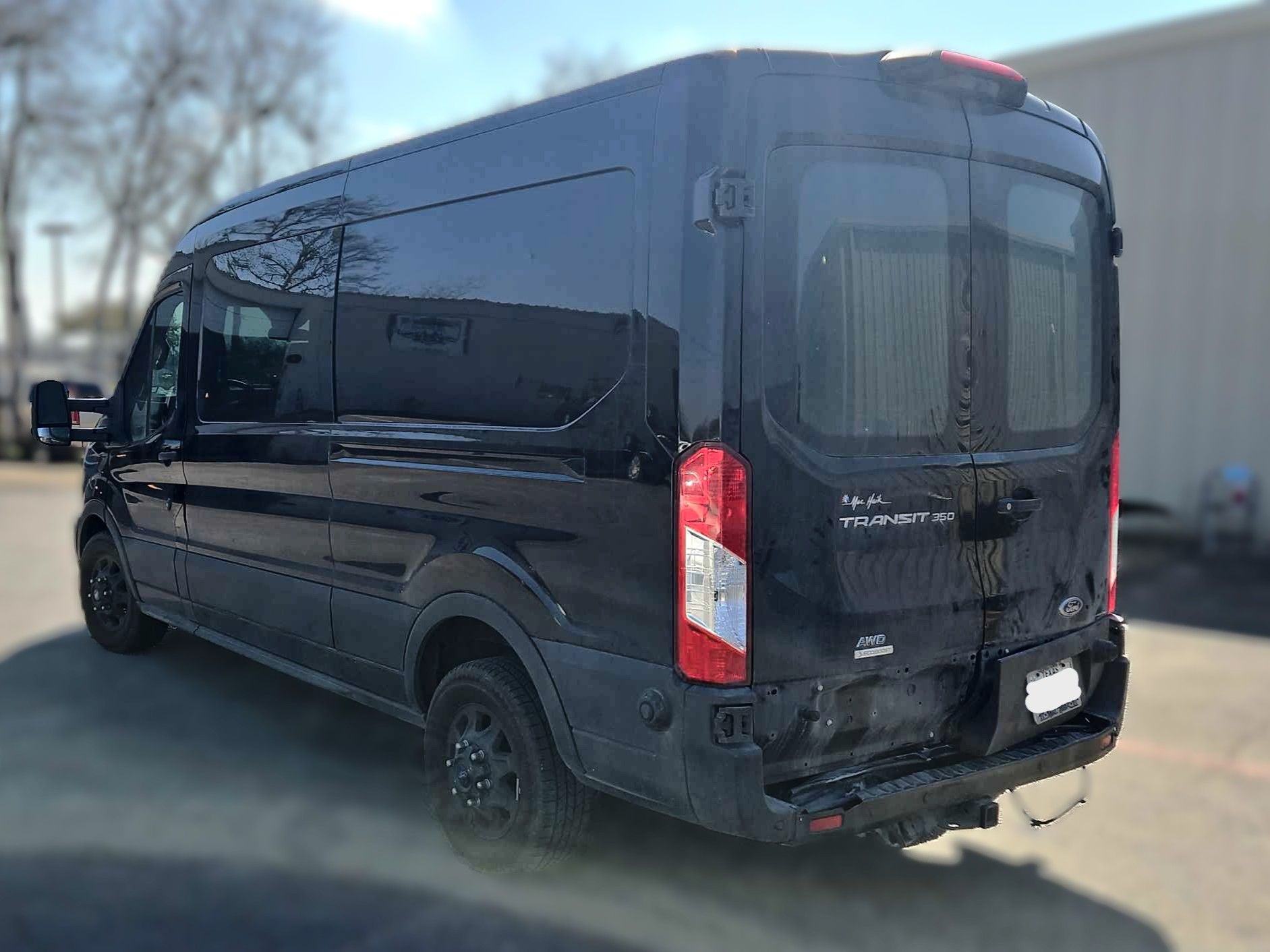 Black Ford Transit van parked outdoors.