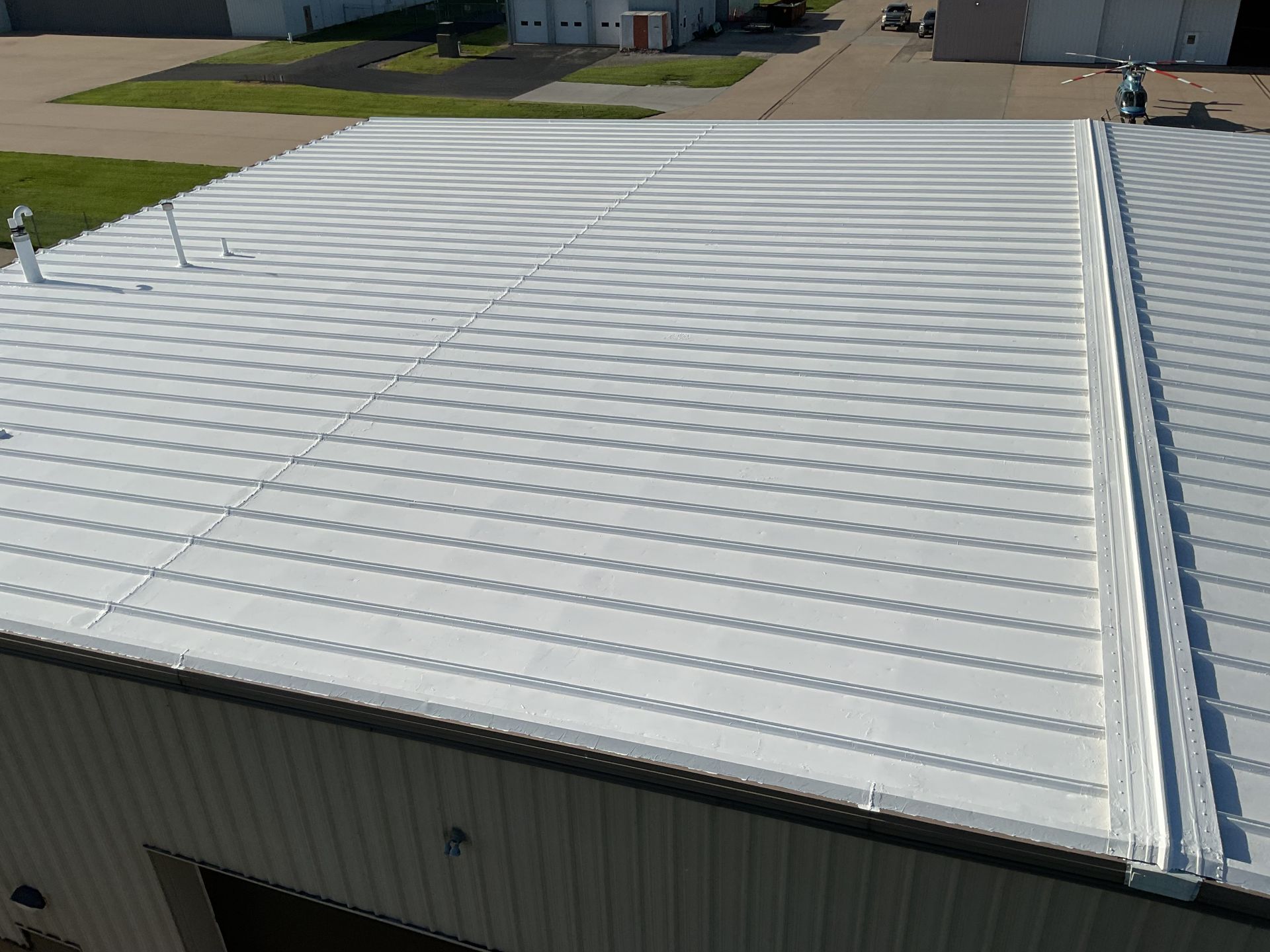 White corrugated metal roof on an industrial building, viewed from above.