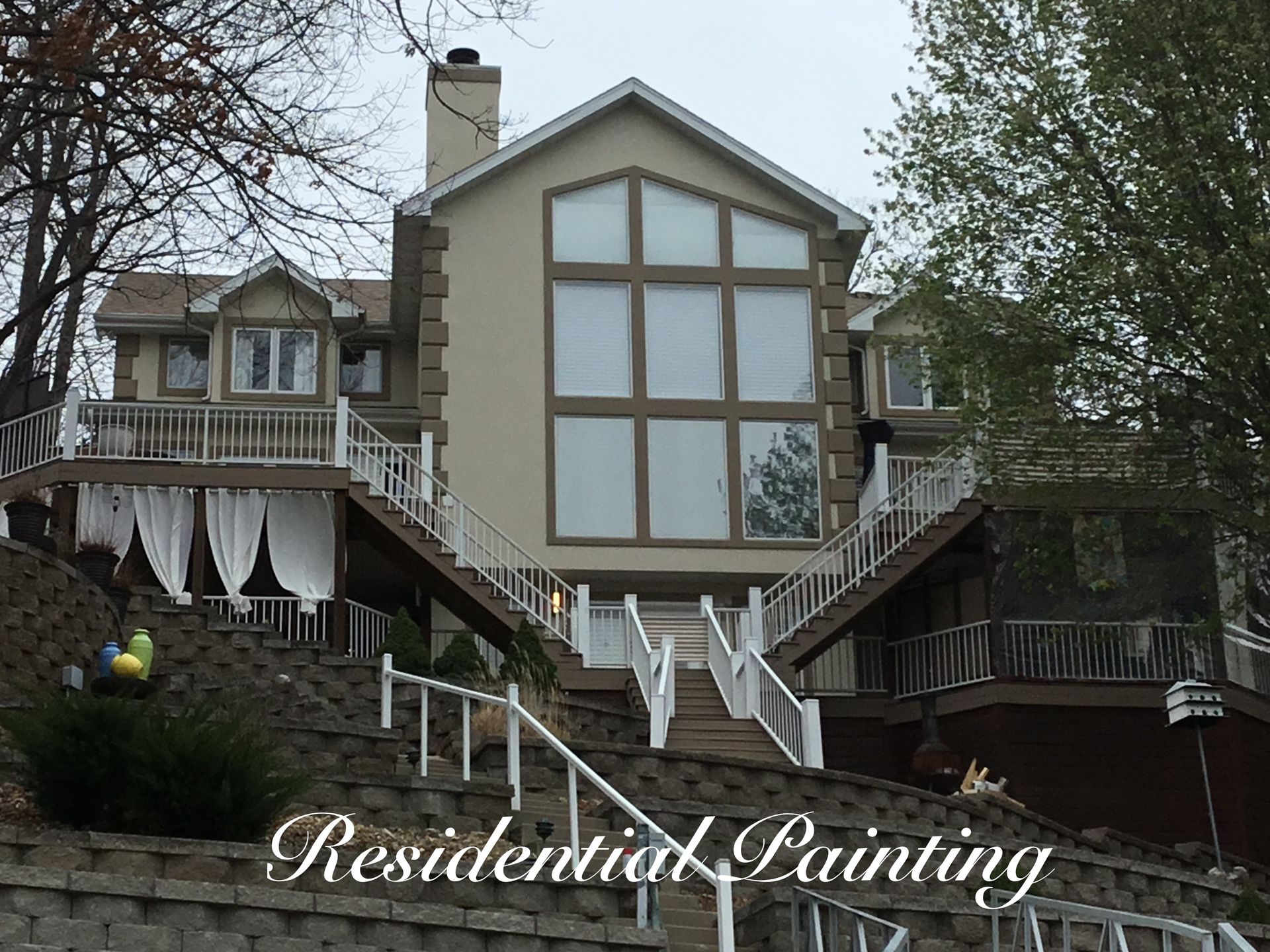 Residential Painting sign over a gray house with large windows and white trim
