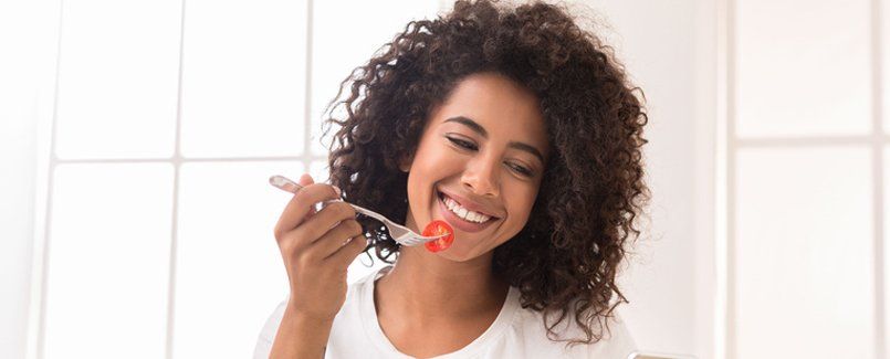 Woman eating tomato