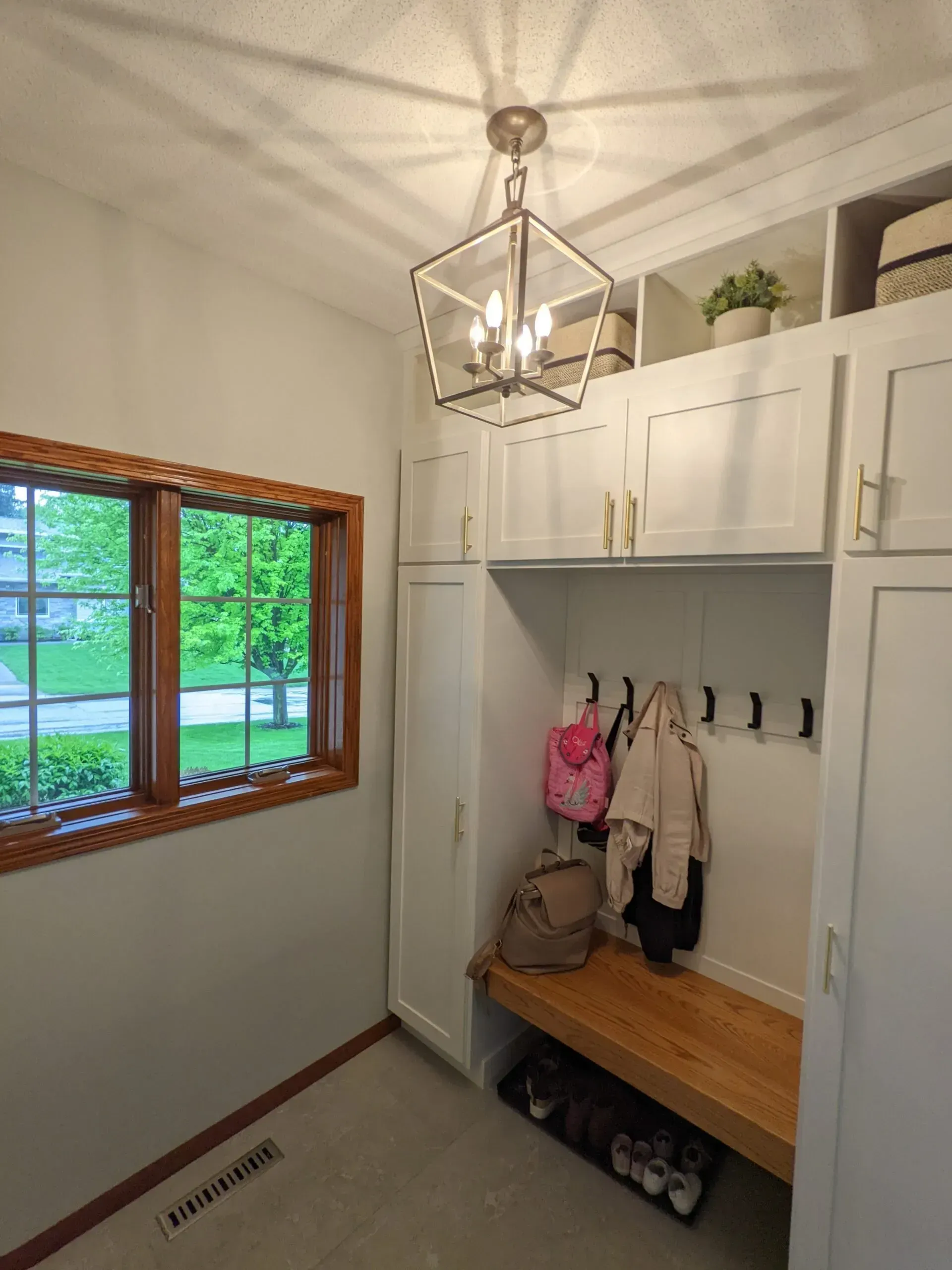 A mud room with a bench and a window.