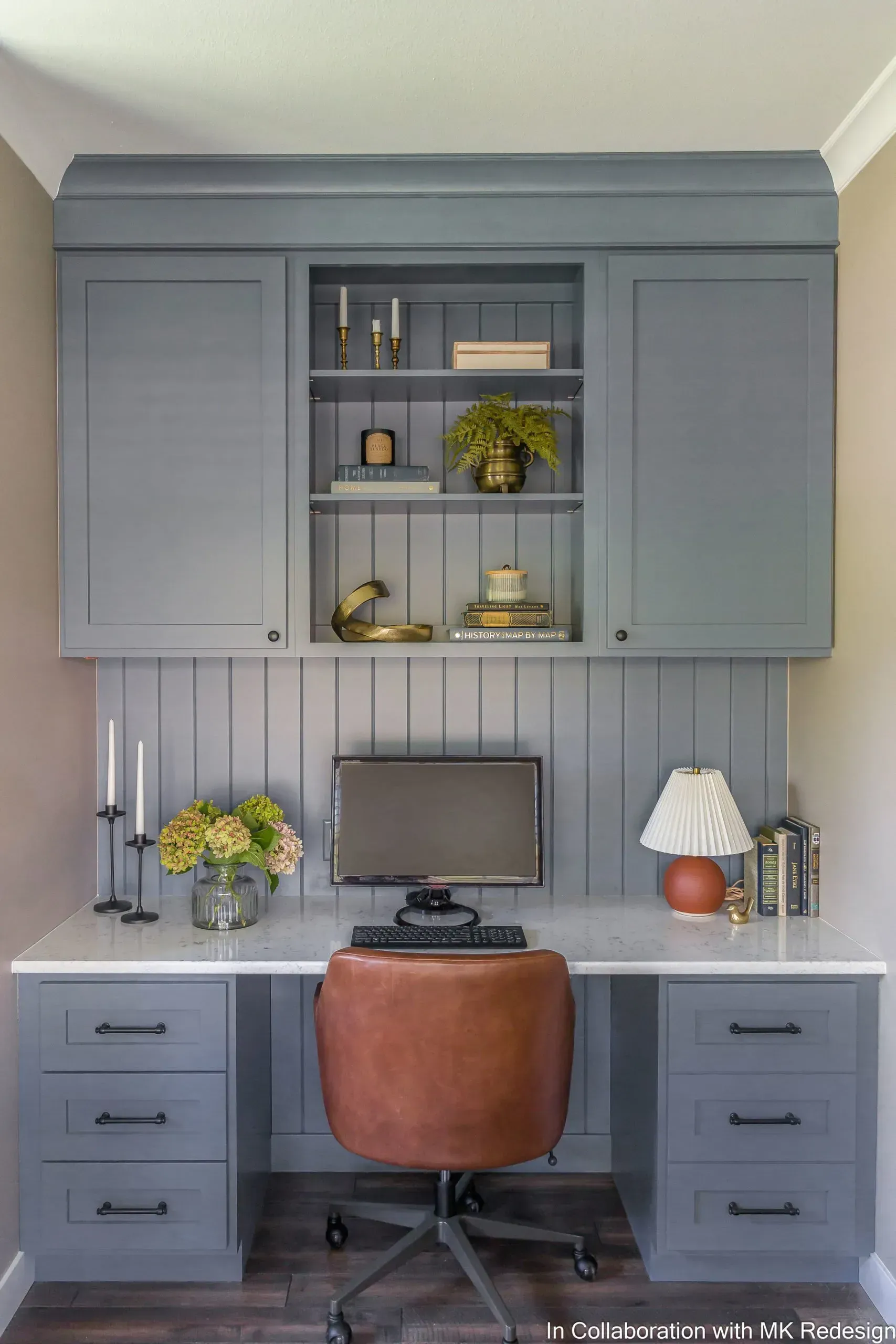 There is a desk with a computer on it and a chair.