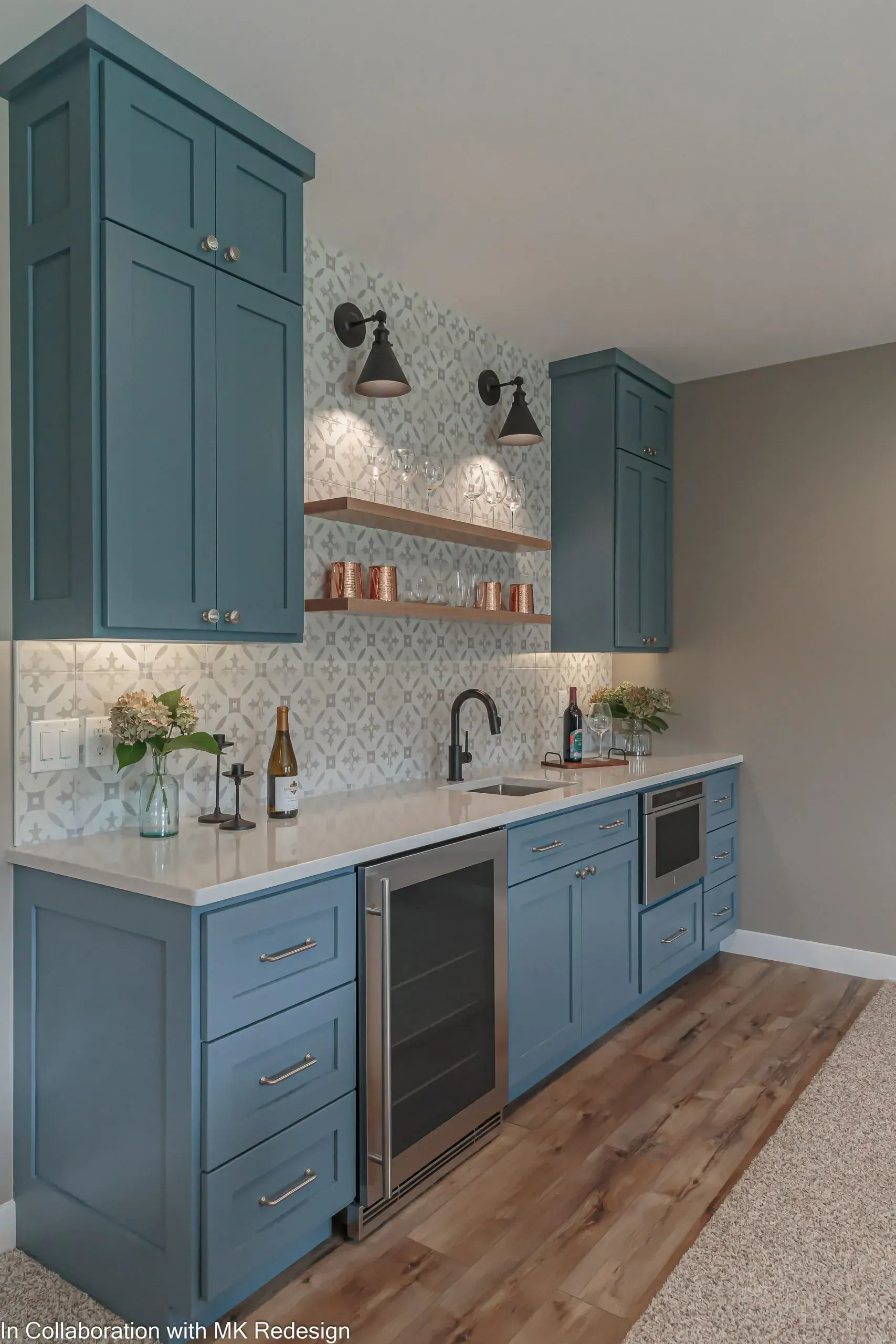 A kitchen with blue cabinets and a stainless steel refrigerator.