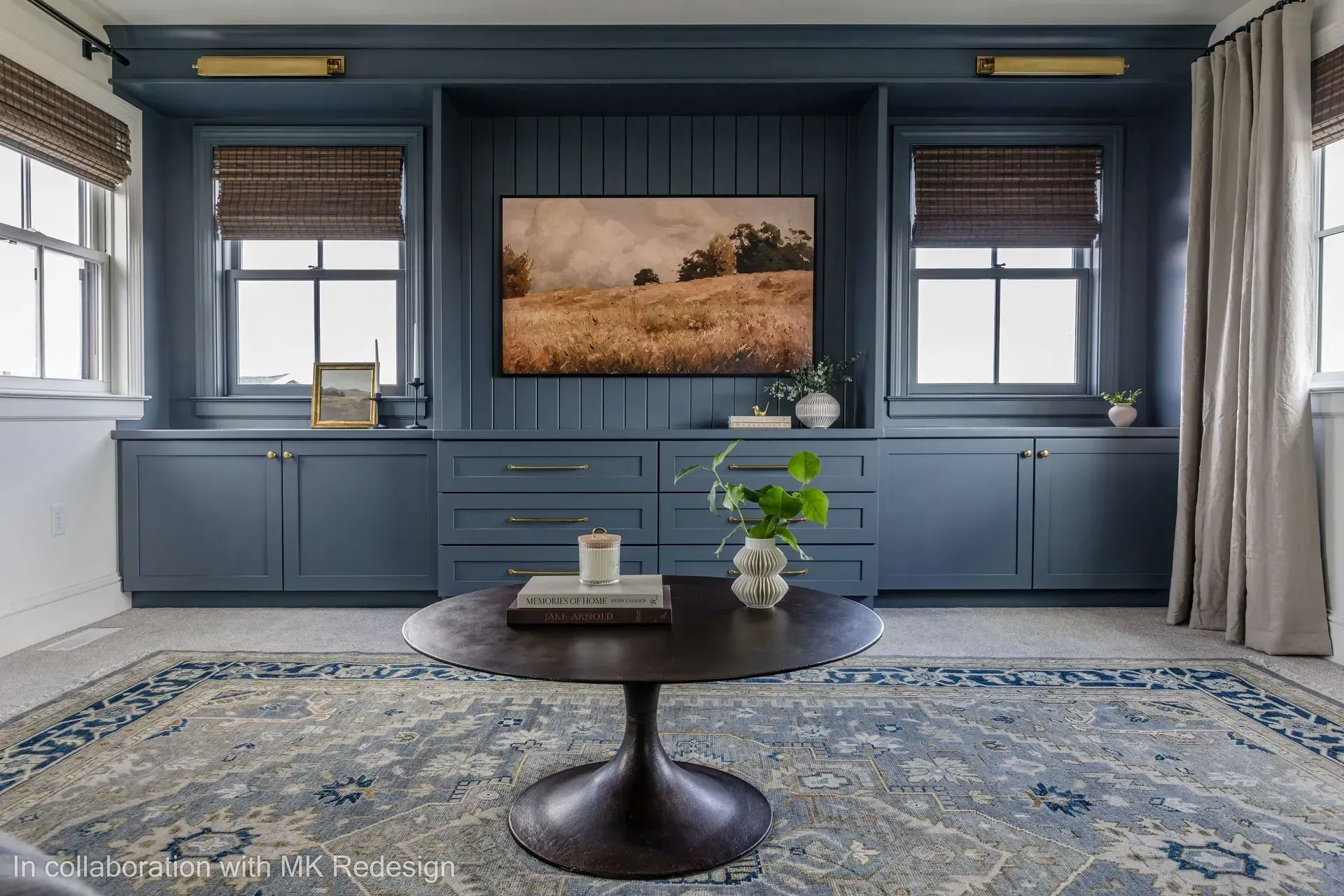 A living room with blue cabinets , a coffee table , and a flat screen tv.