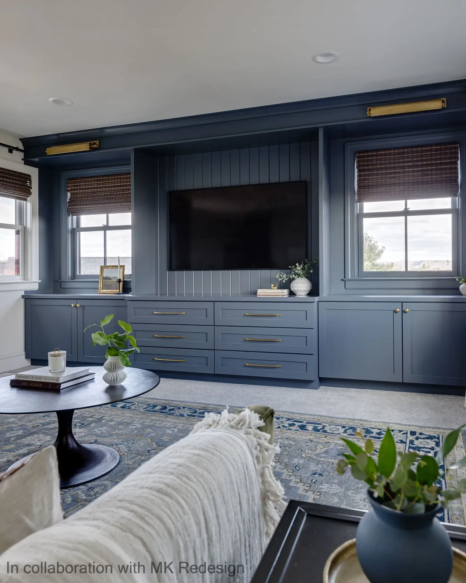 A living room with blue cabinets and a flat screen tv.