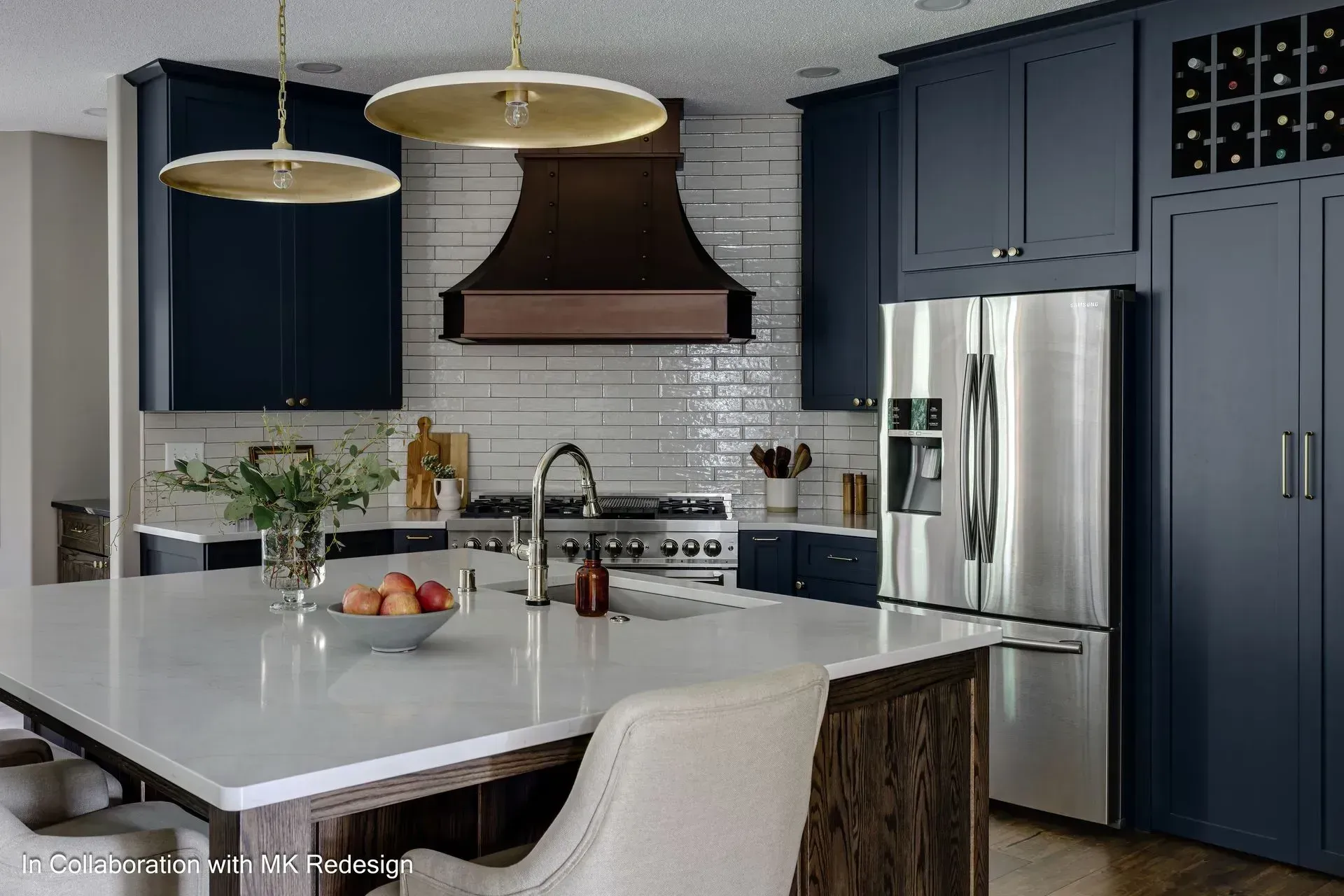 A kitchen with blue cabinets , stainless steel appliances , and a large island.