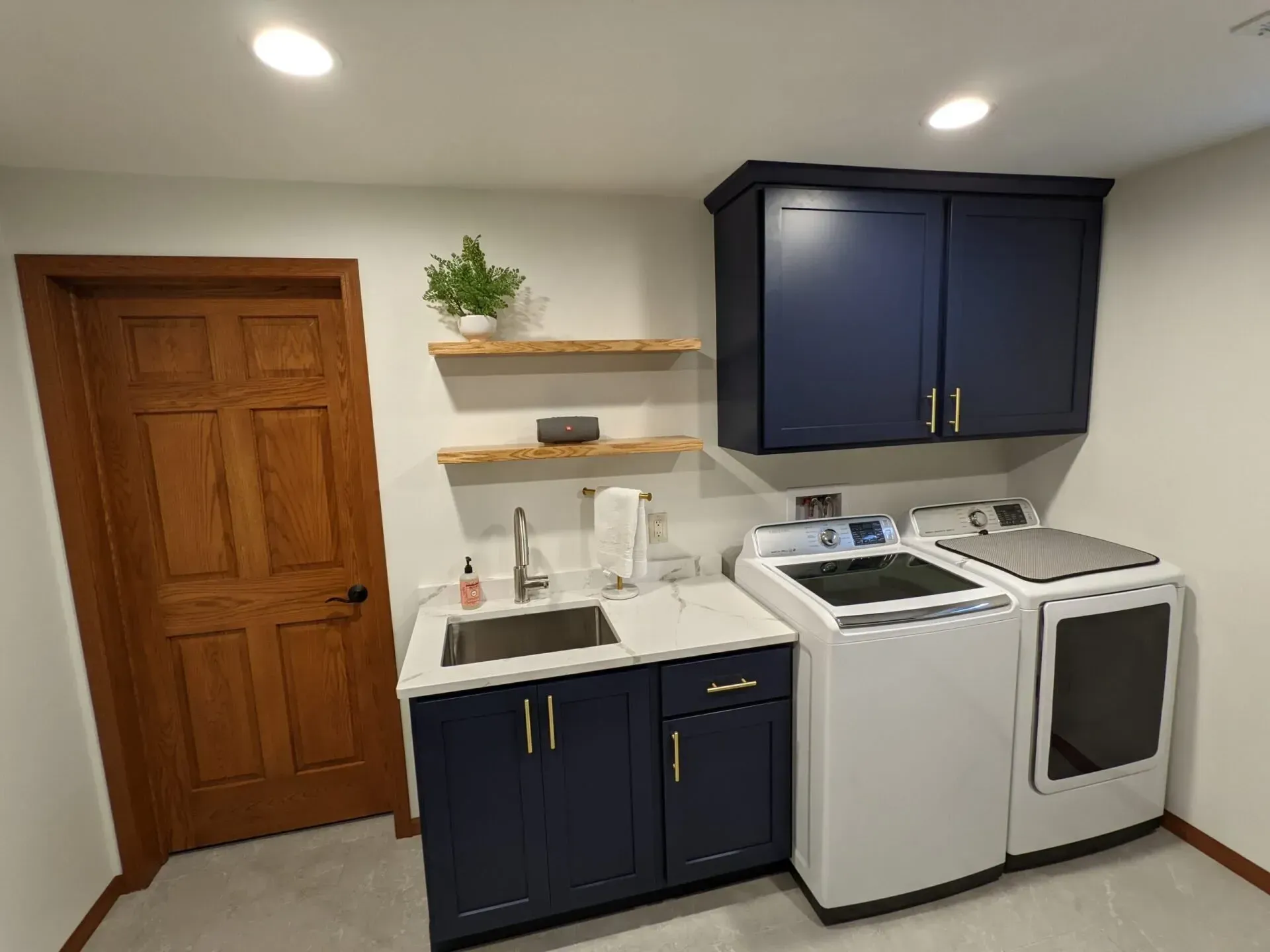 A laundry room with a washer and dryer , sink , and cabinets.