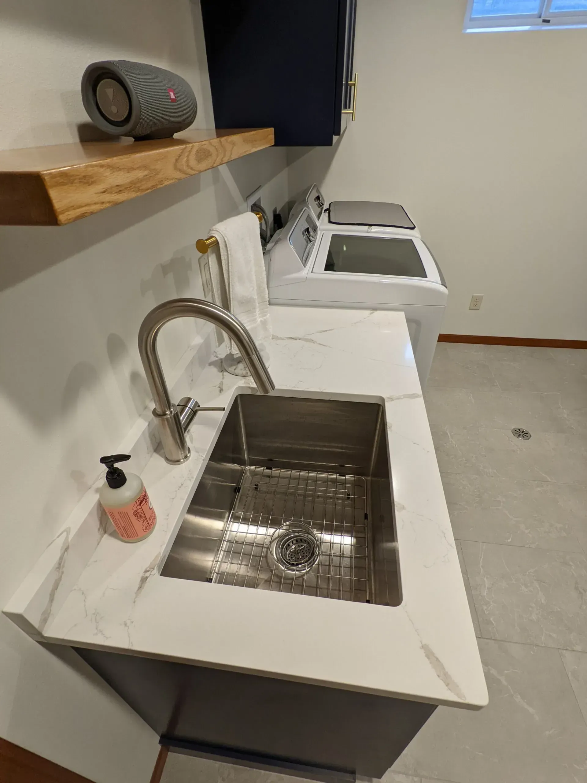 A laundry room with a sink , washer and dryer.