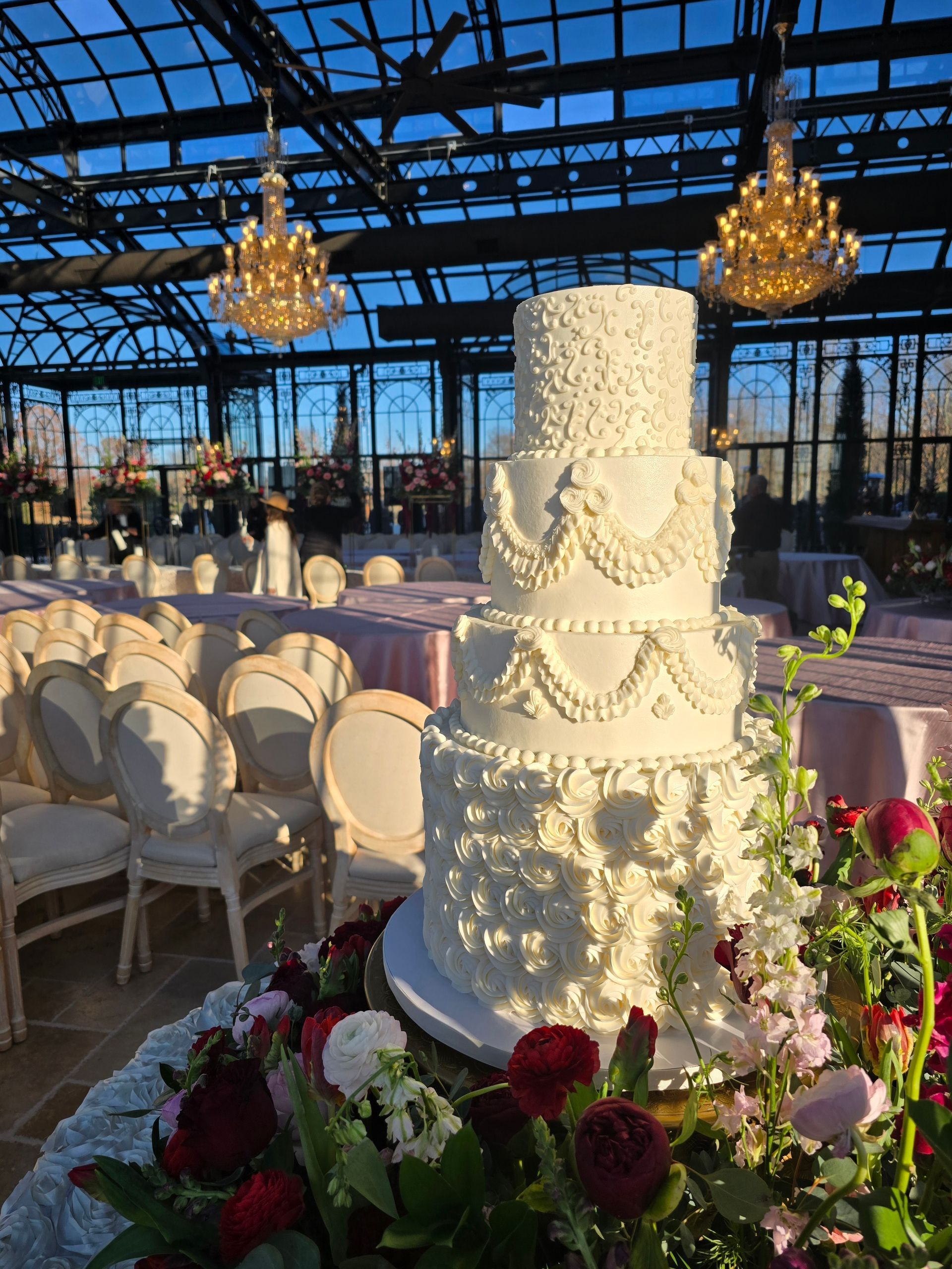 A wedding cake is sitting on top of a table with flowers.