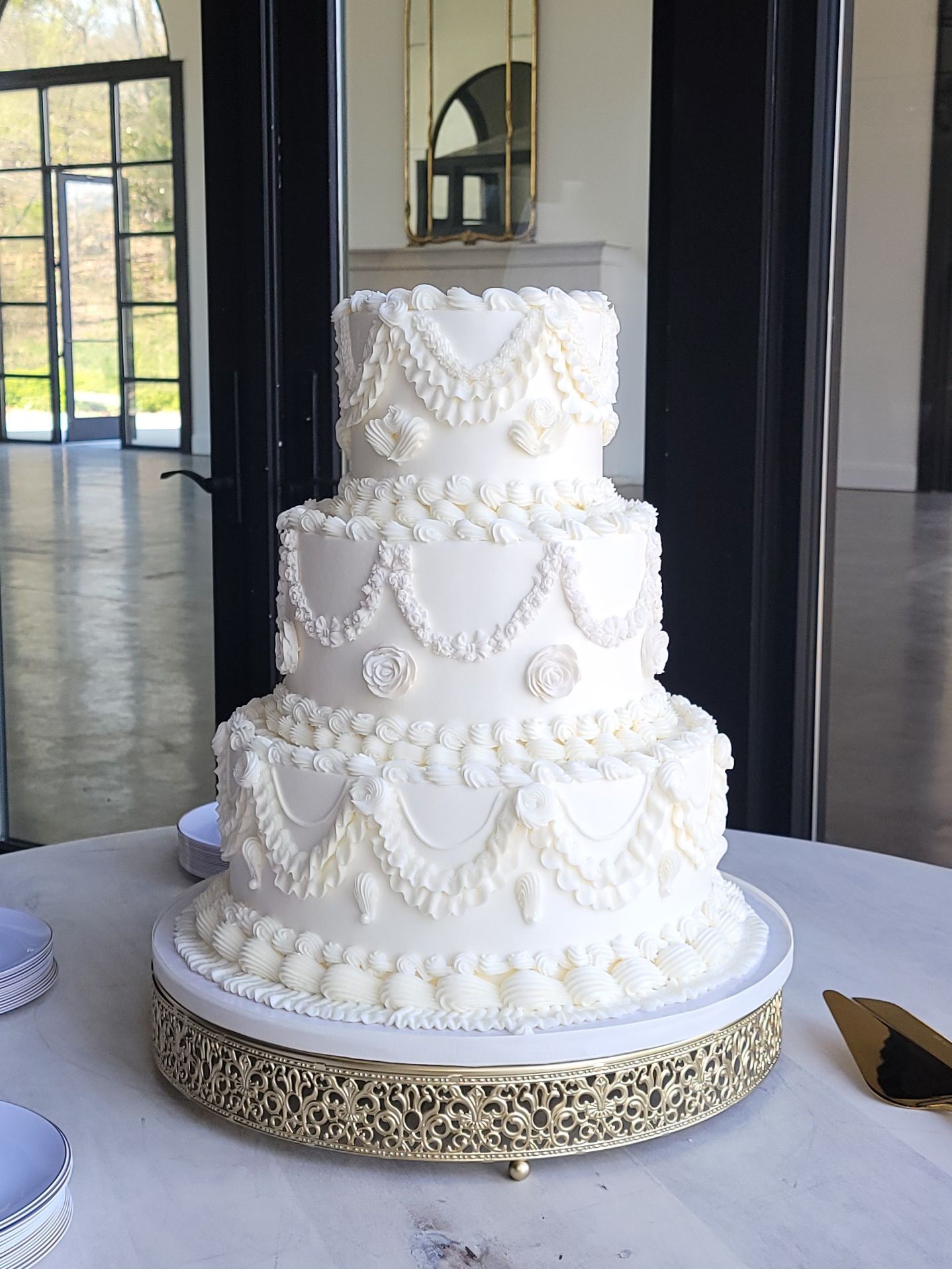 A white wedding cake is sitting on top of a table.