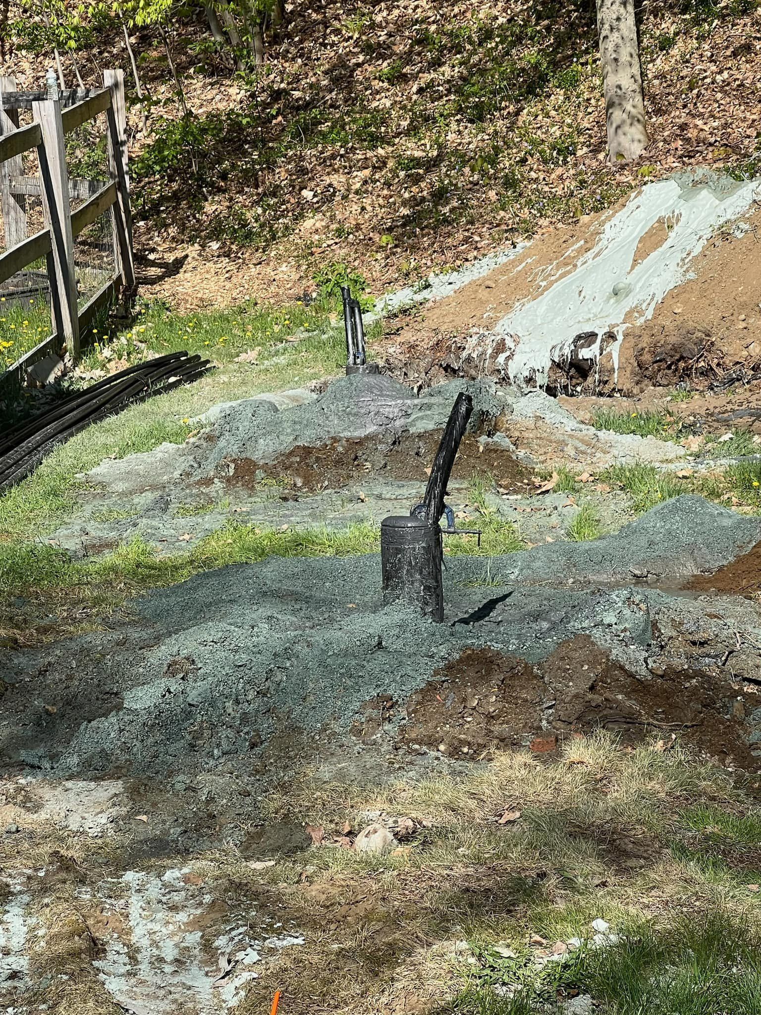 A large green and blue truck is parked in a dirt field.