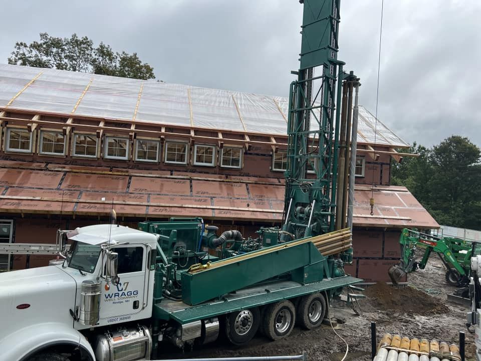 A large truck is parked in front of a building under construction.