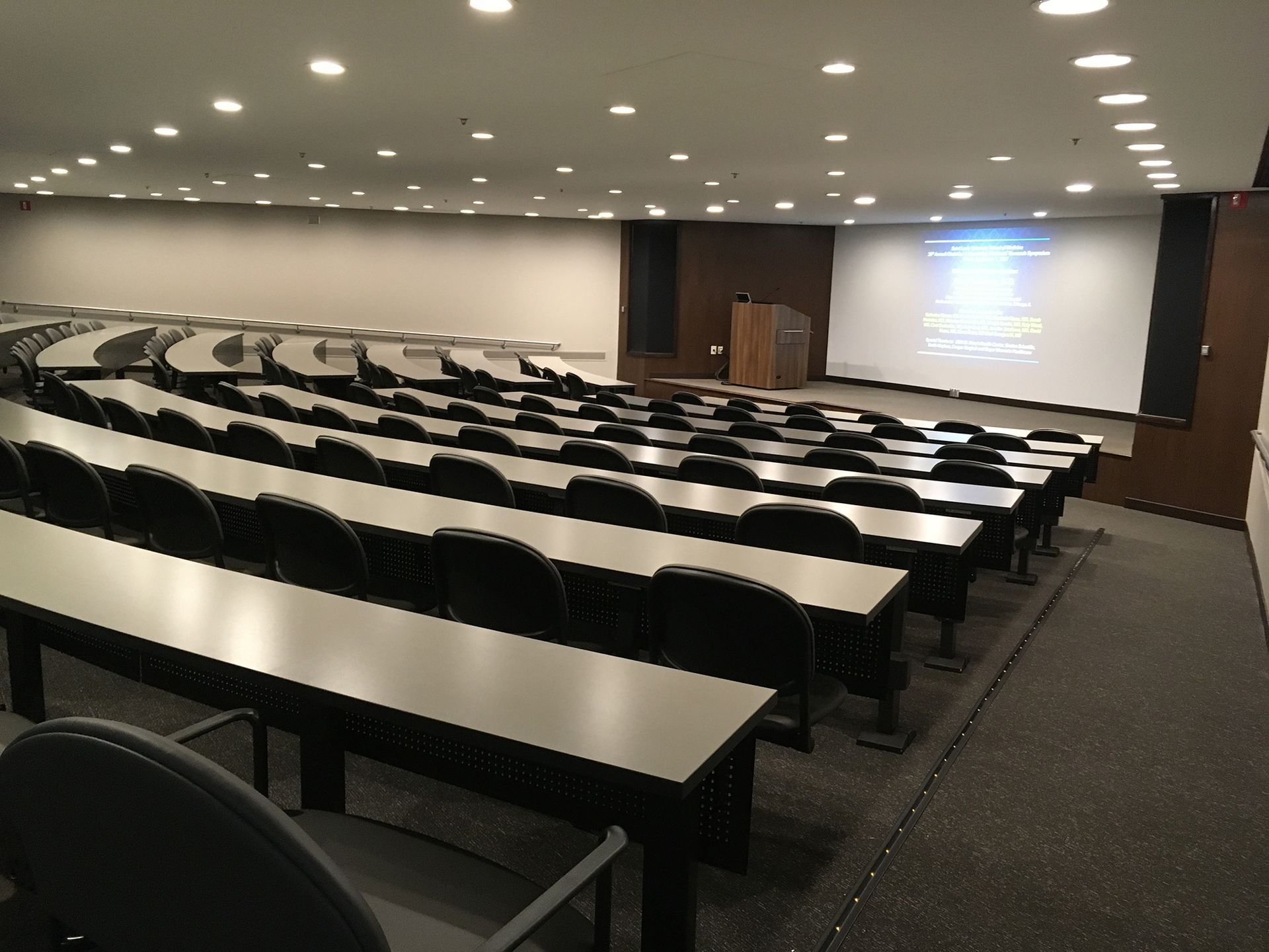 A large lecture hall with rows of tables and chairs