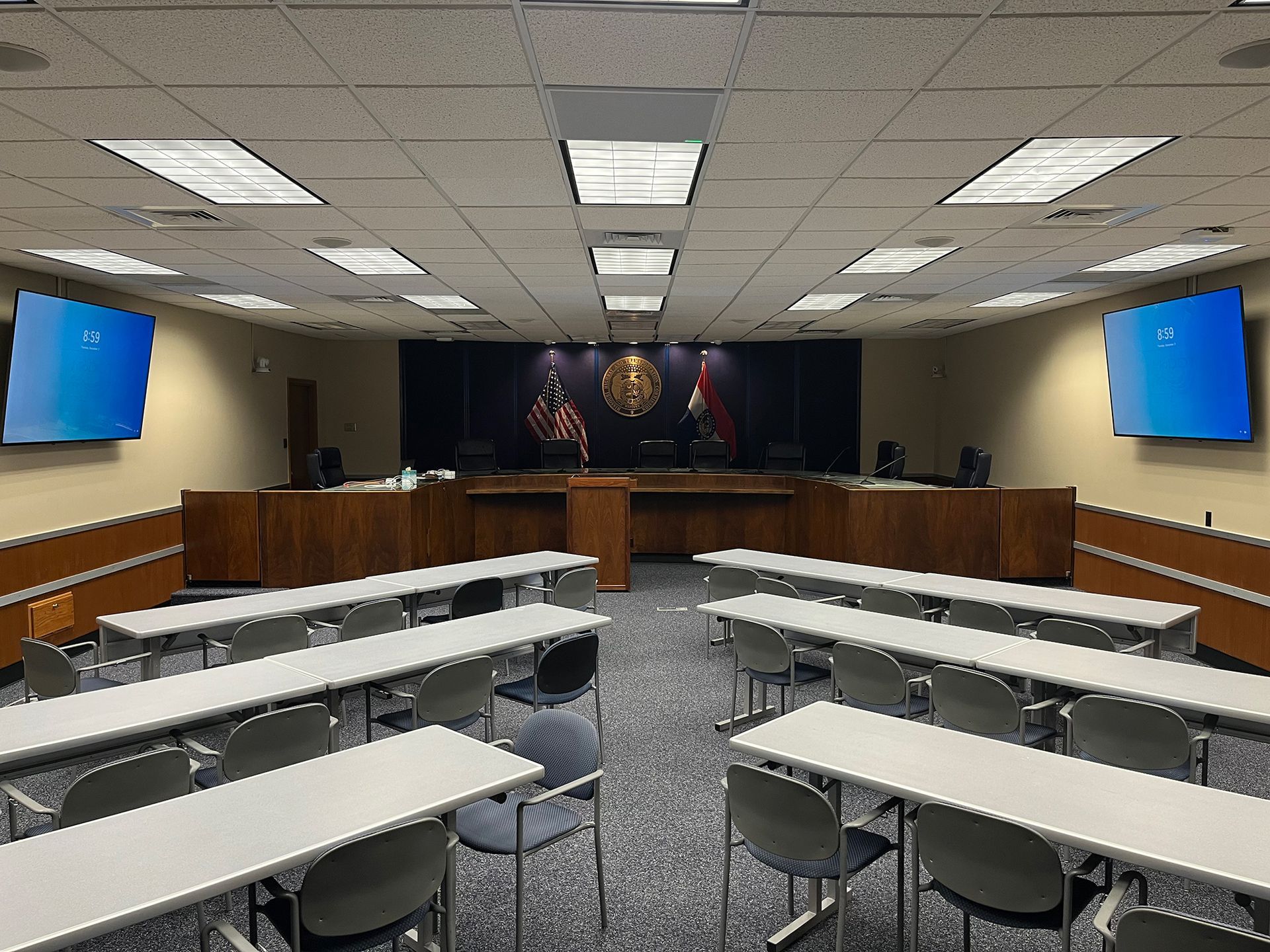 A large conference room with tables and chairs and a podium.