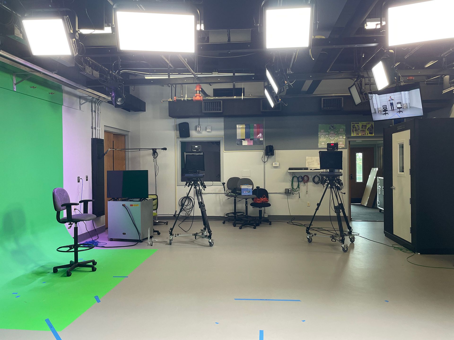 There is a green screen in the middle of the room.