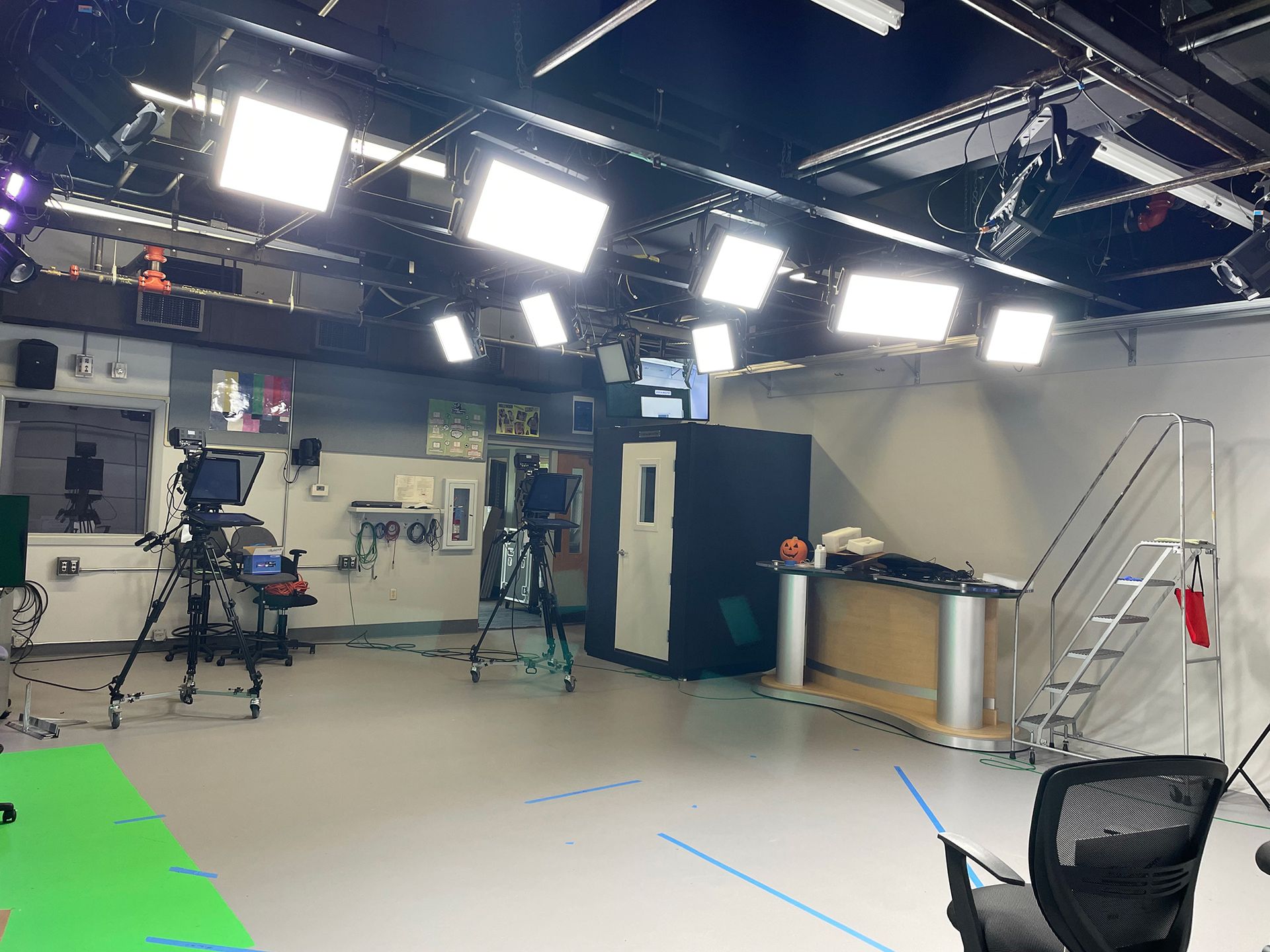 A large room with a green screen and lots of lights
