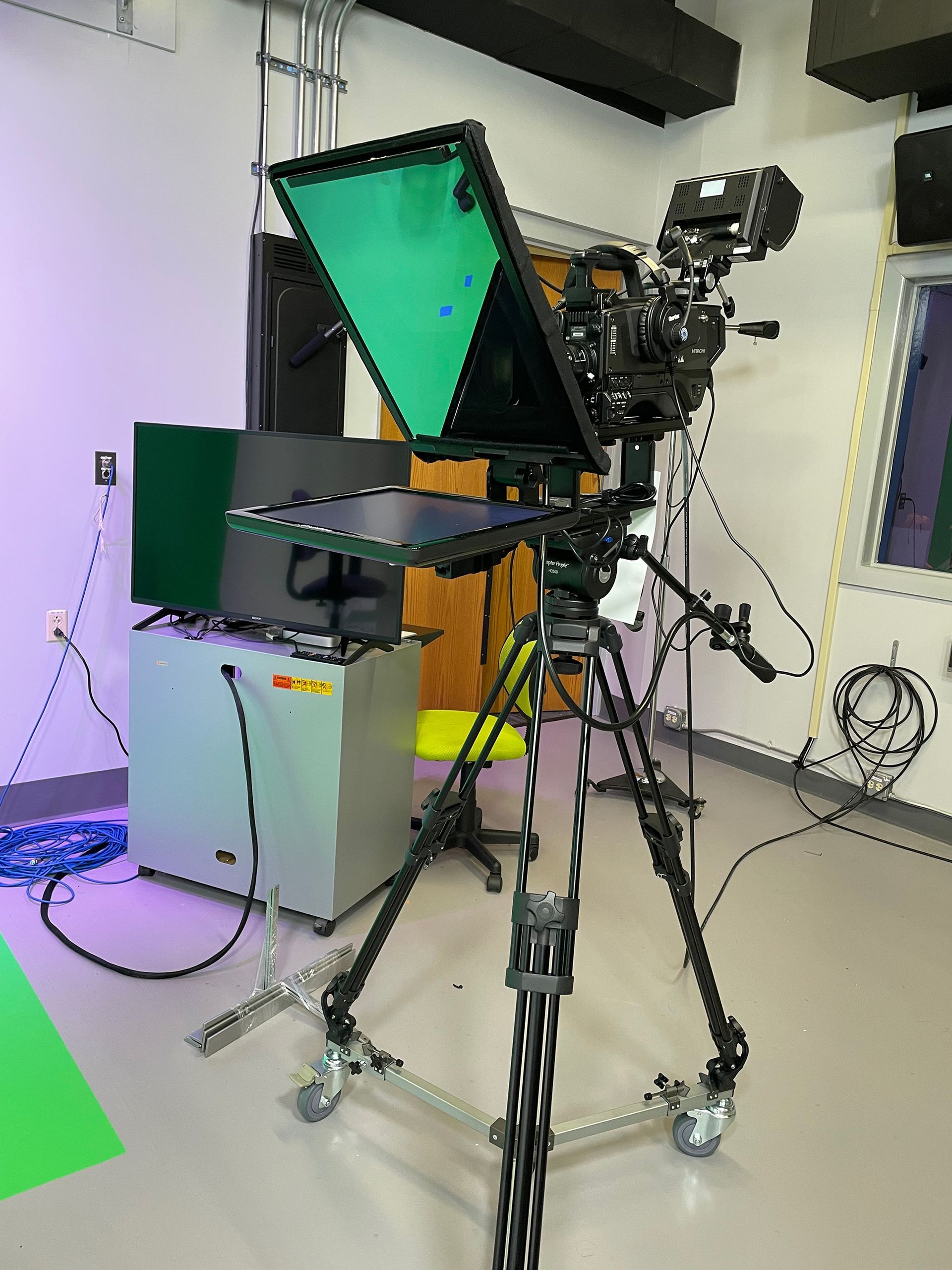 A camera is sitting on a tripod in a room.