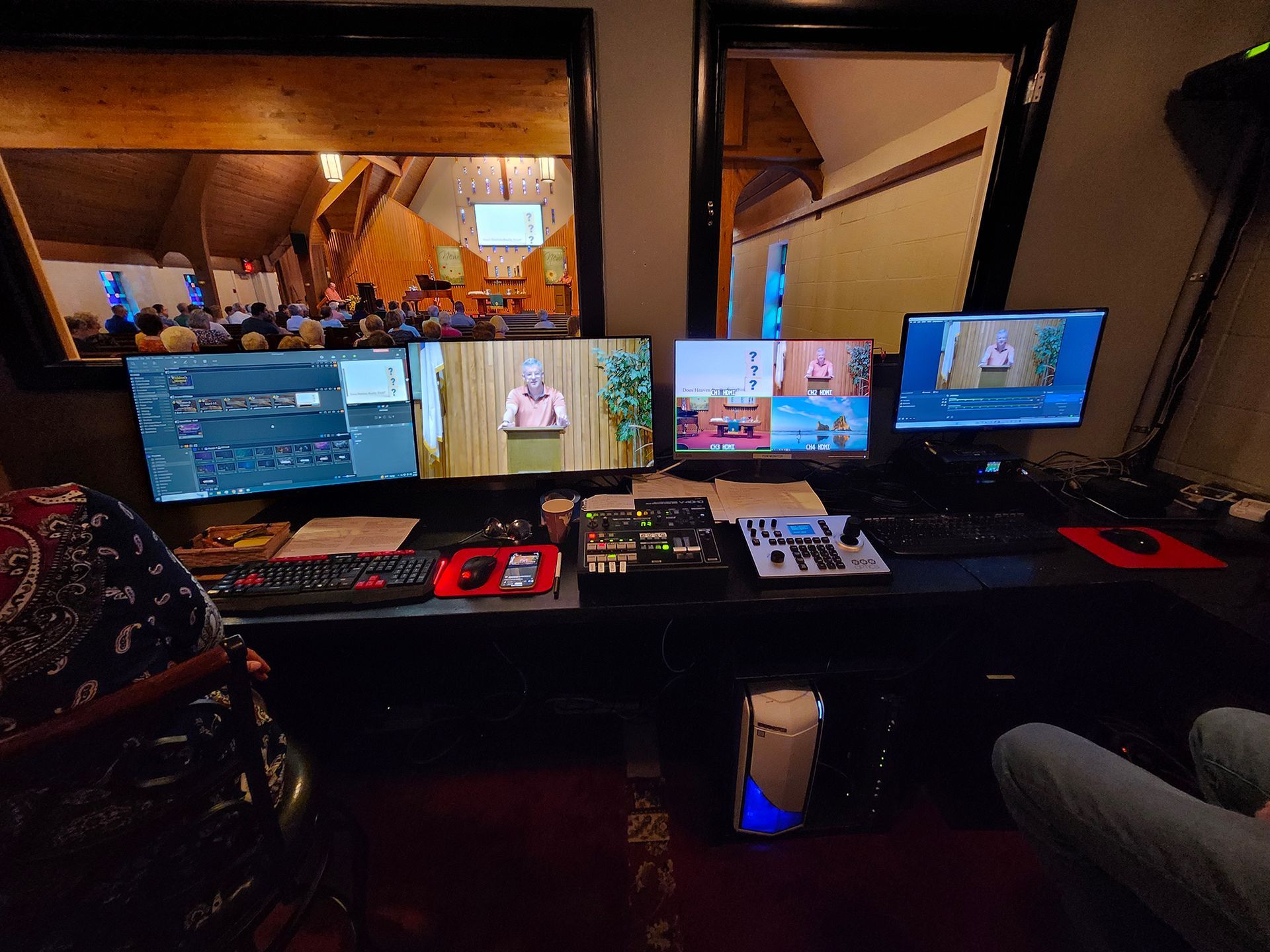A computer desk with three monitors and a keyboard