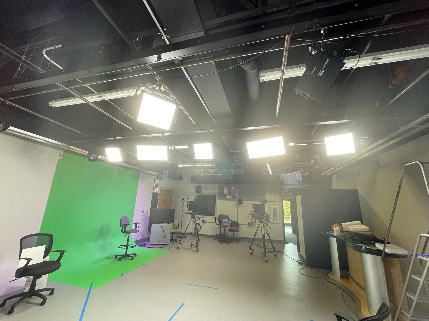 There is a green screen in the middle of the room.