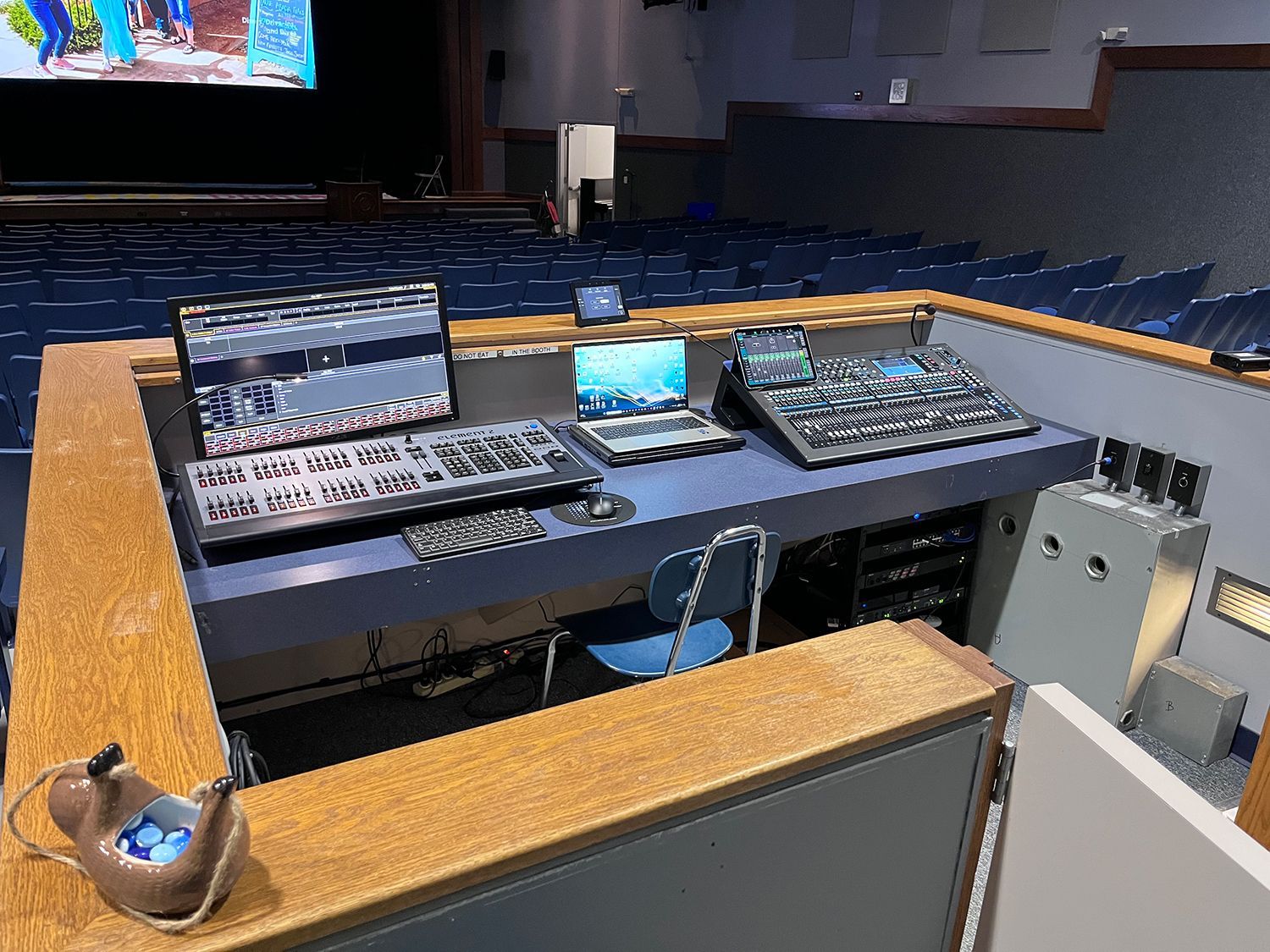 A podium in an auditorium with a laptop on top of it.