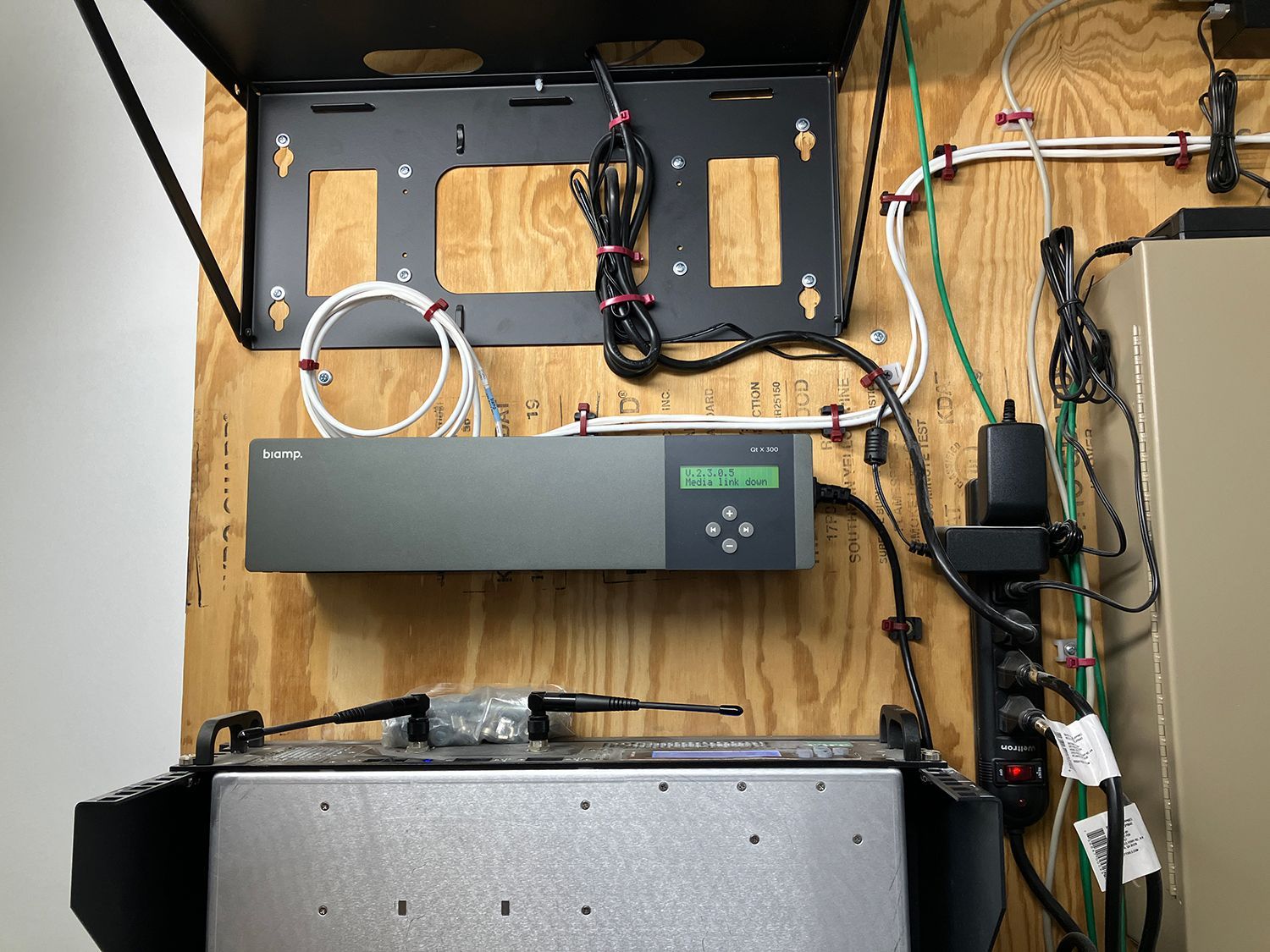A wooden wall with a bunch of wires connected to it