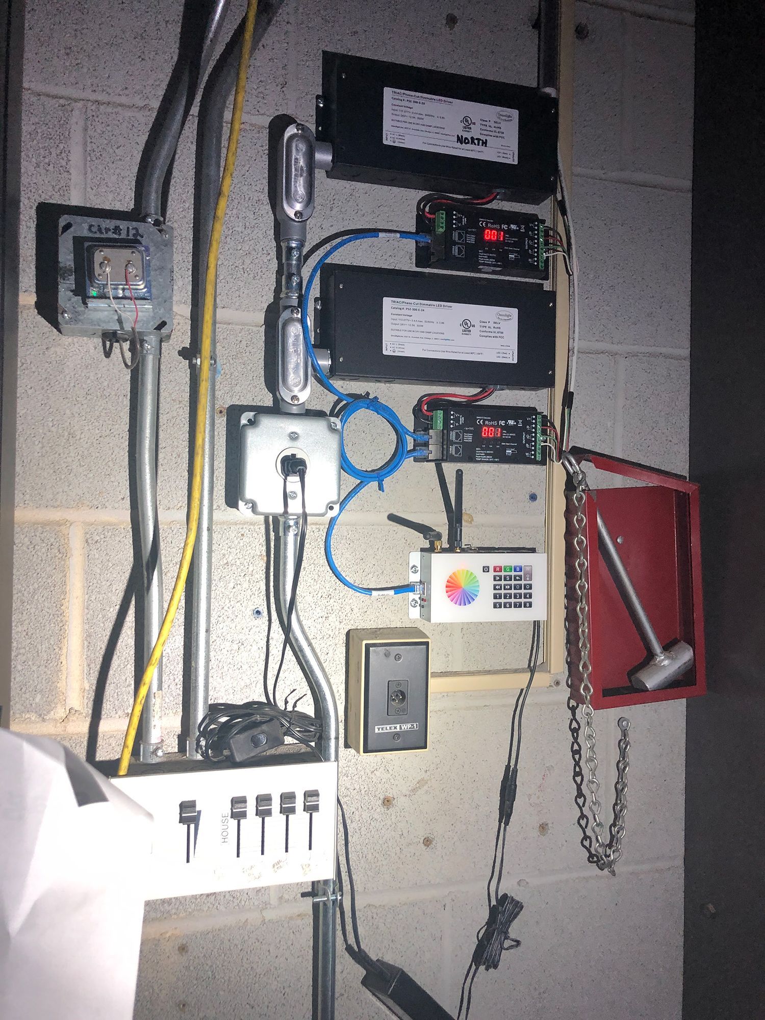 A brick wall with a bunch of wires connected to it