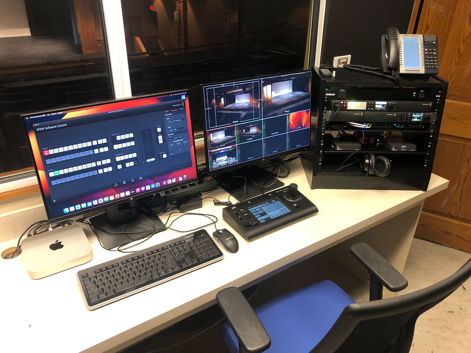 A desk with two computer monitors and a keyboard on it.