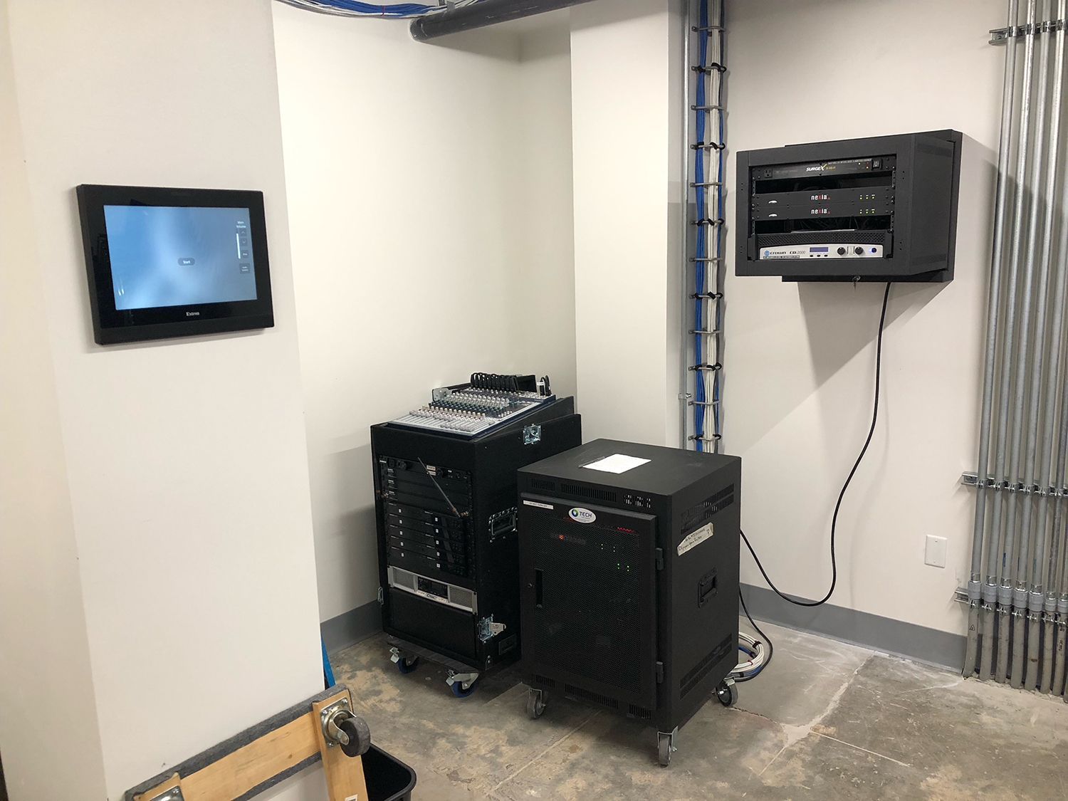 A room with a computer and a tv on the wall.