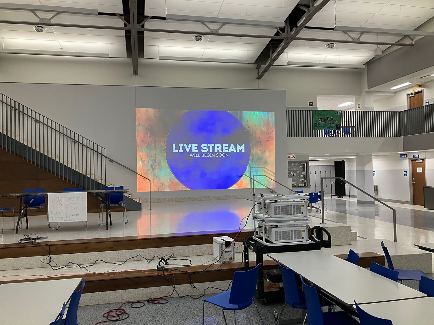 There is a large screen in the middle of the room that says live stream.