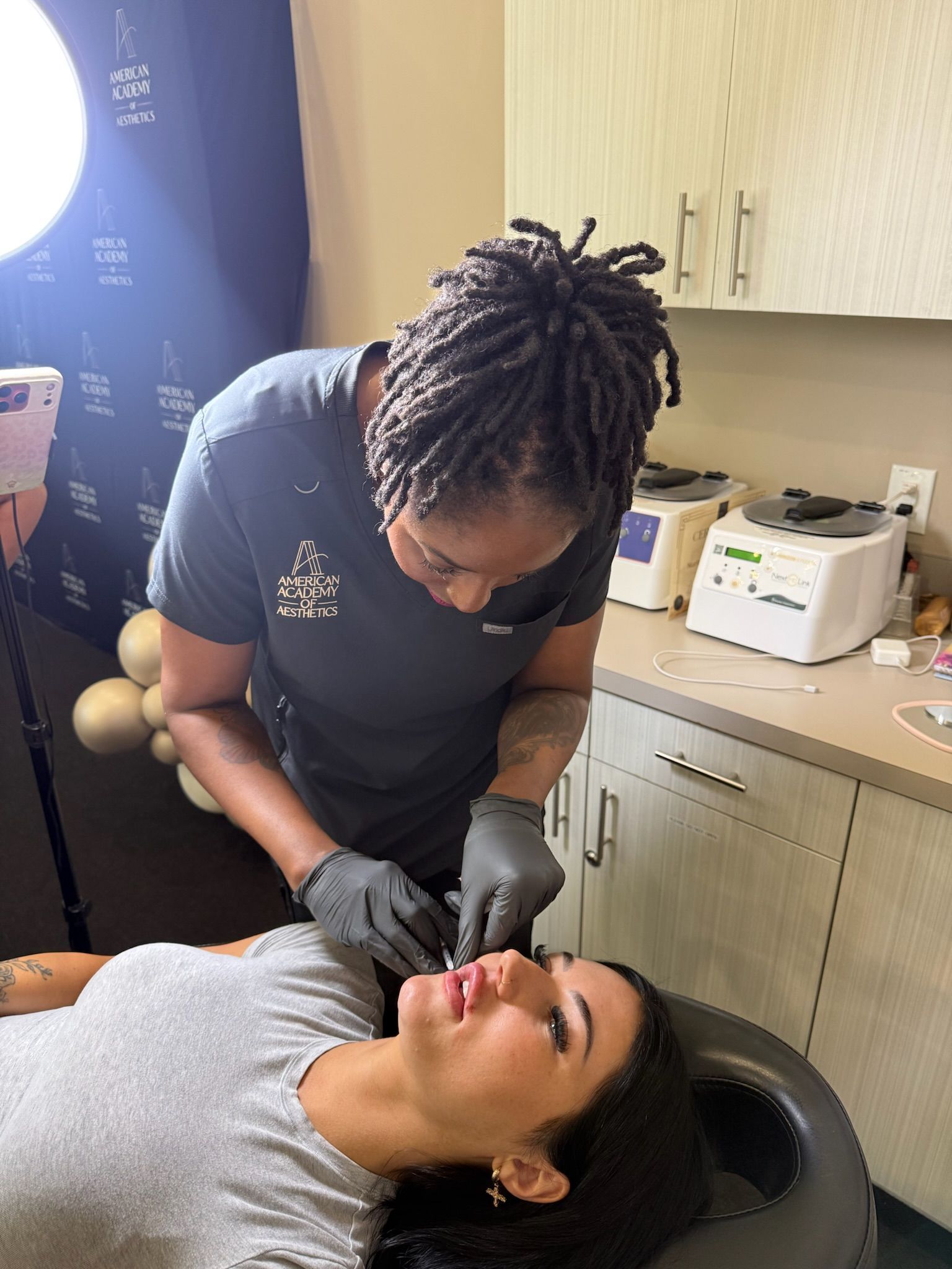 An aesthetics student practices a supervised lip filler injection technique during hands-on training in Coppell, TX