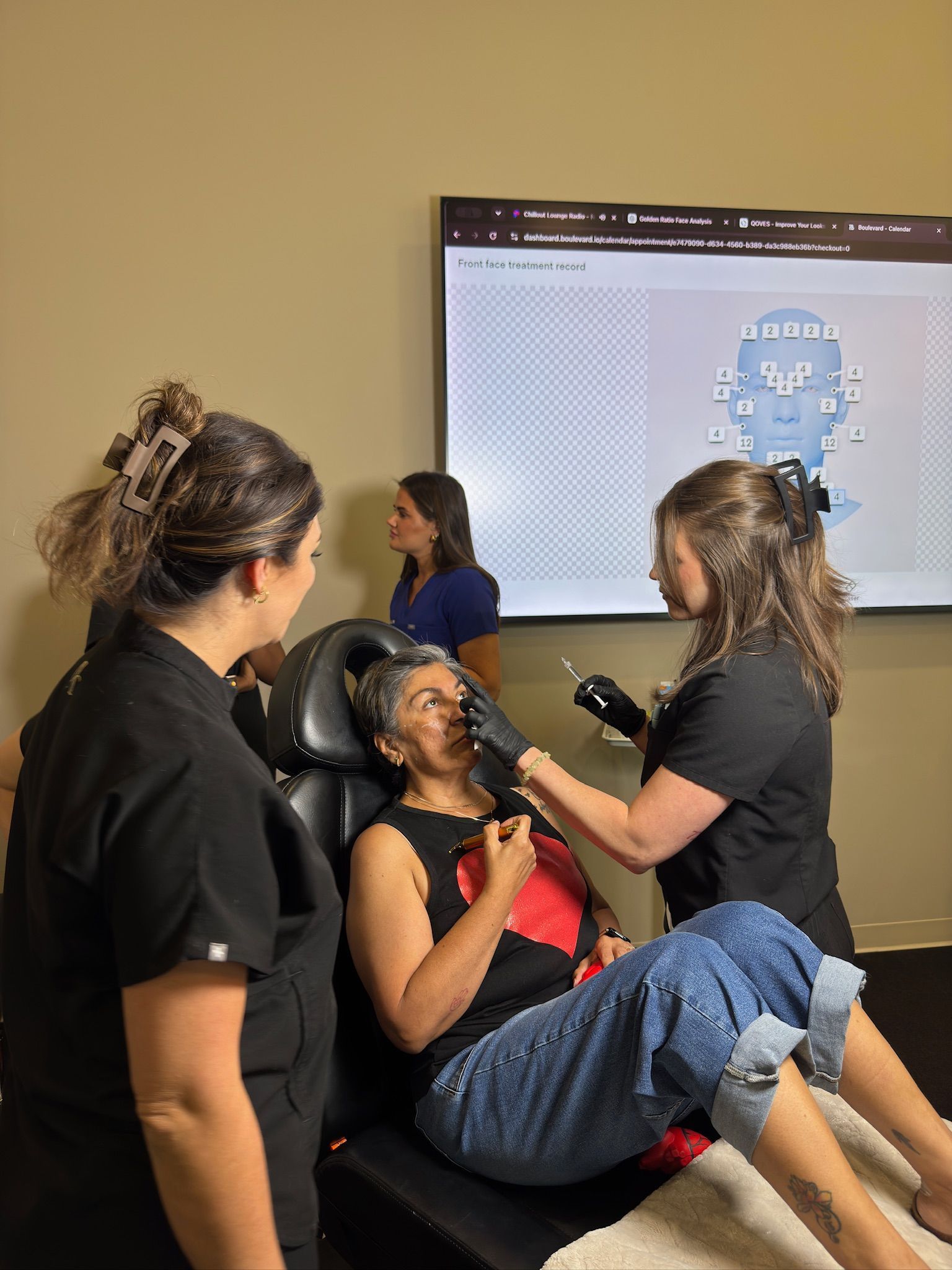 A student practices a supervised facial neurotoxin injection while reviewing a treatment map during hands-on training in Arlington, TX