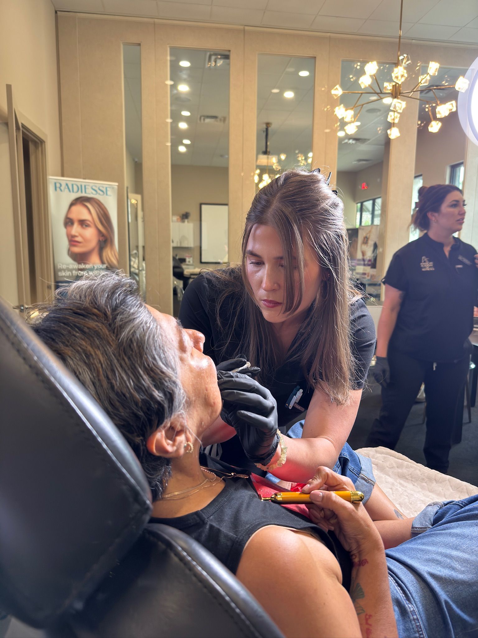 A student practices a supervised lower-face filler injection during hands-on cosmetic injectable training in Grapevine, TX
