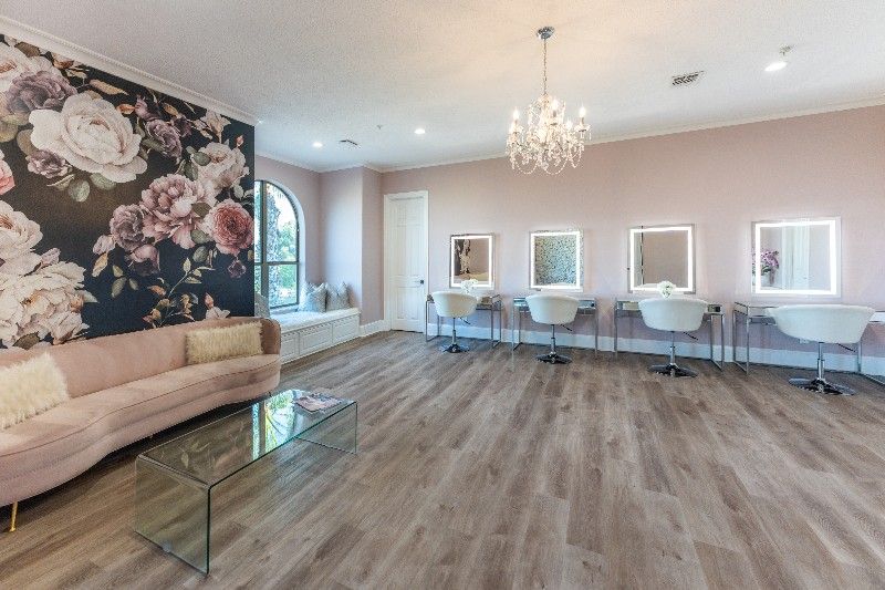 A large room with a couch , mirrors , and a chandelier.