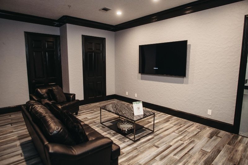 A living room with a couch , chair , coffee table and television.