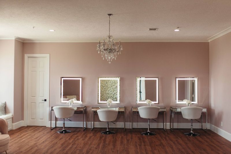 A room with a lot of mirrors and chairs in it.