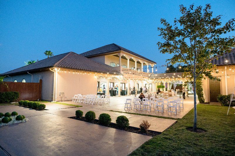 A large house with a lot of tables and chairs in front of it.
