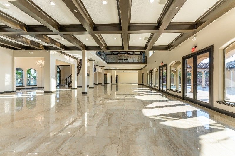 A large empty room with a lot of windows and marble floors.
