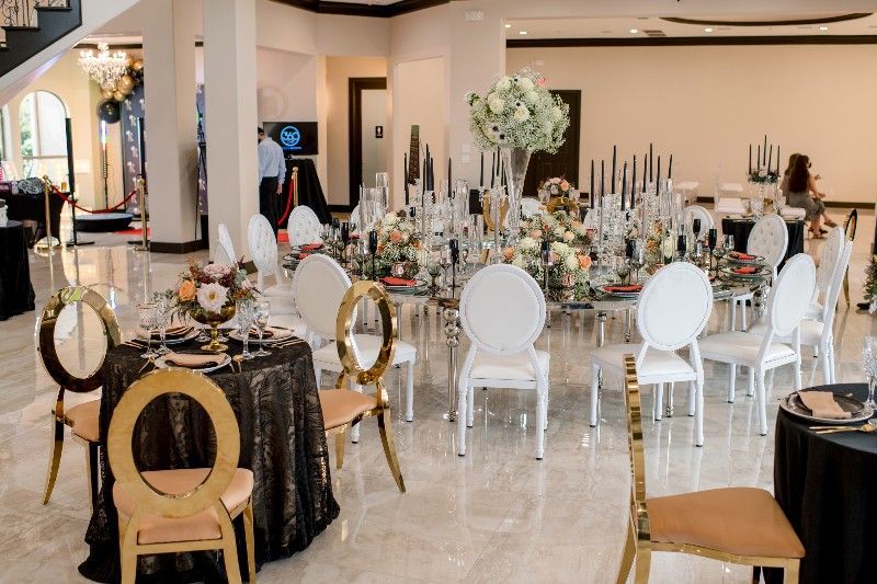 A large room with tables and chairs set up for a wedding reception.