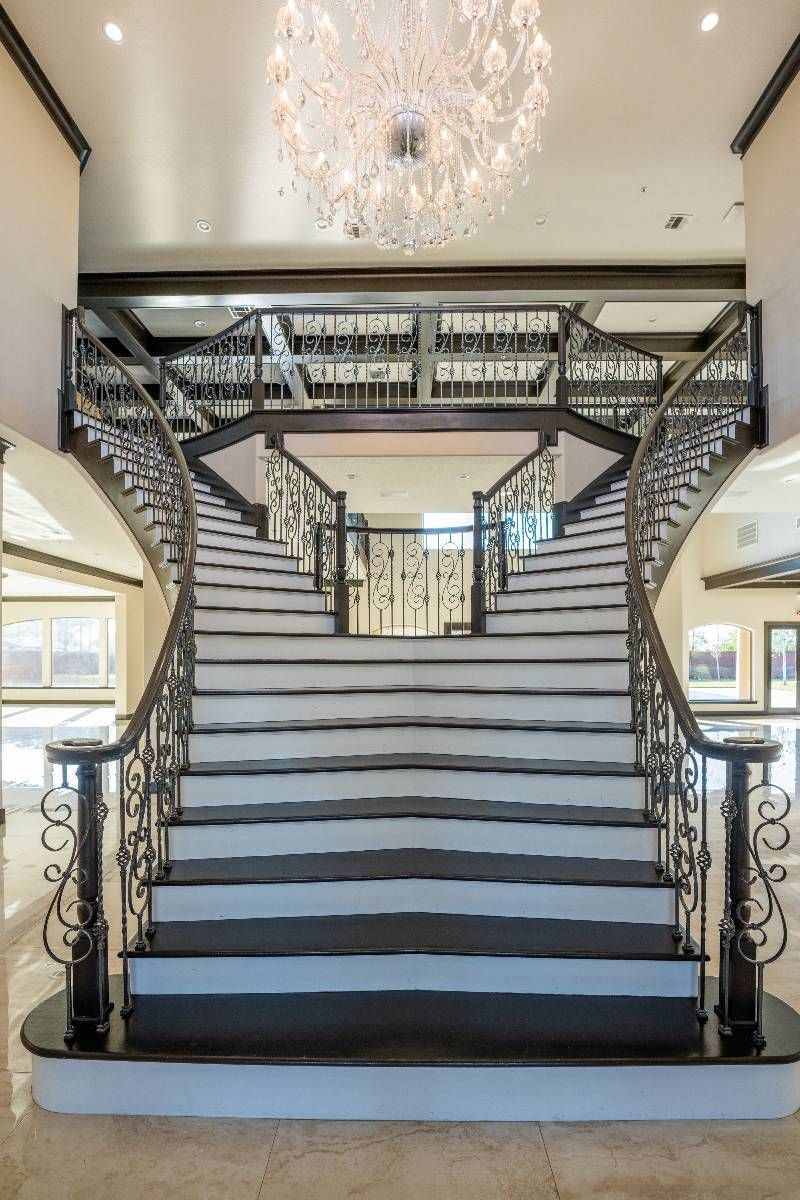 A large staircase with a chandelier hanging from the ceiling.