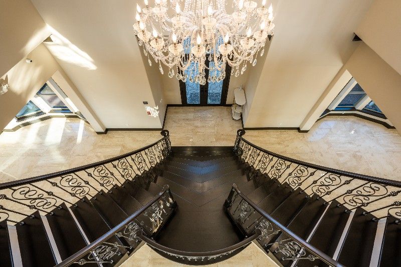 An aerial view of a staircase with a chandelier hanging from the ceiling