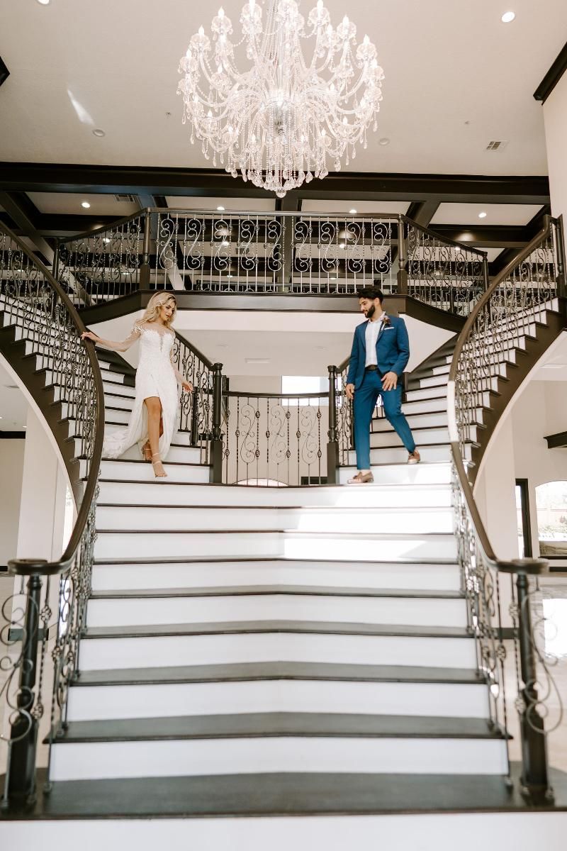 A bride and groom are standing on top of a set of stairs.