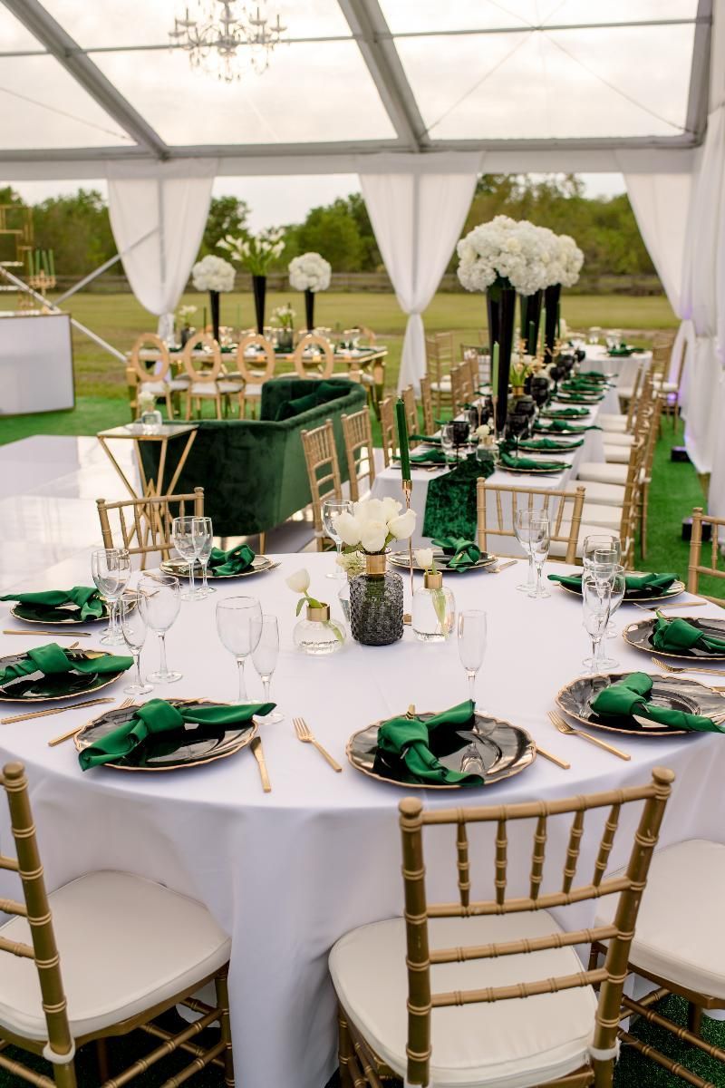 A long table set for a wedding reception under a tent.