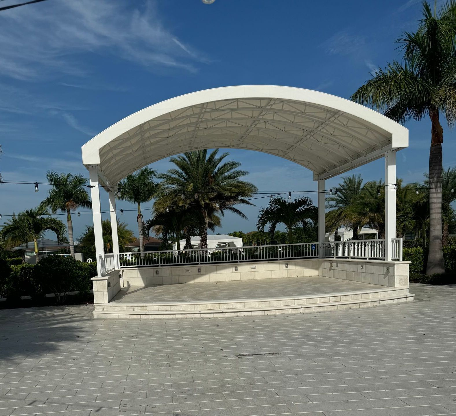 a large white stage with palm trees in the background on a beach .