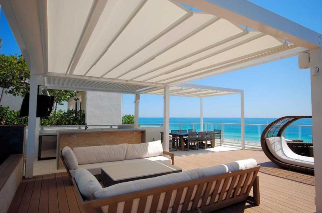 a patio with a couch and a table overlooking the ocean