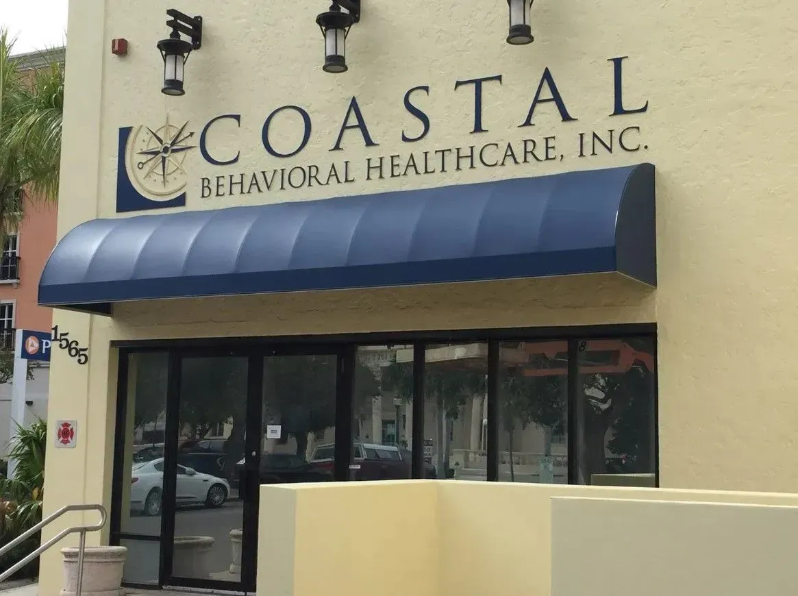 a coastal behavioral healthcare inc. building with a blue awning