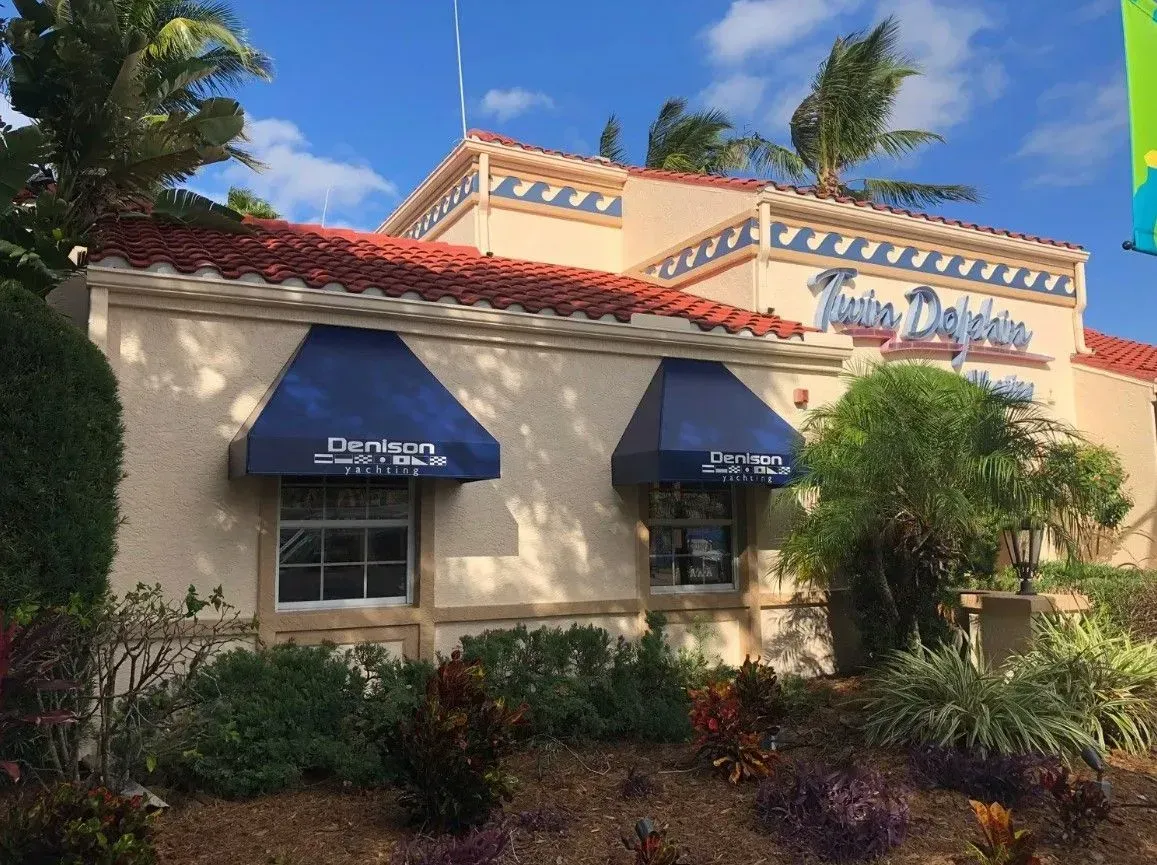 a white building with blue awnings on the windows