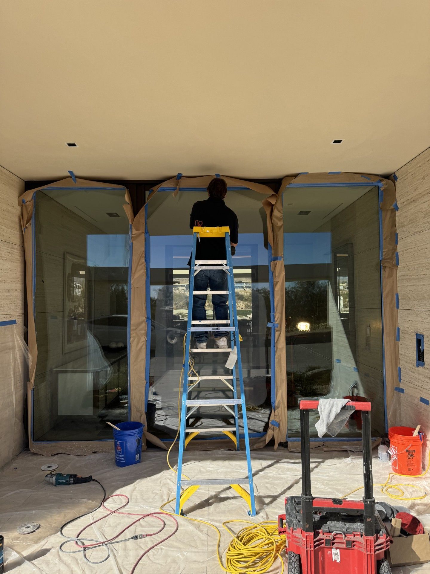 A man is standing on a ladder in front of a building.