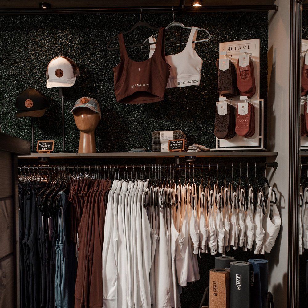 Clothing store display with hats, tops, socks, and hanging clothes; various neutral colors.