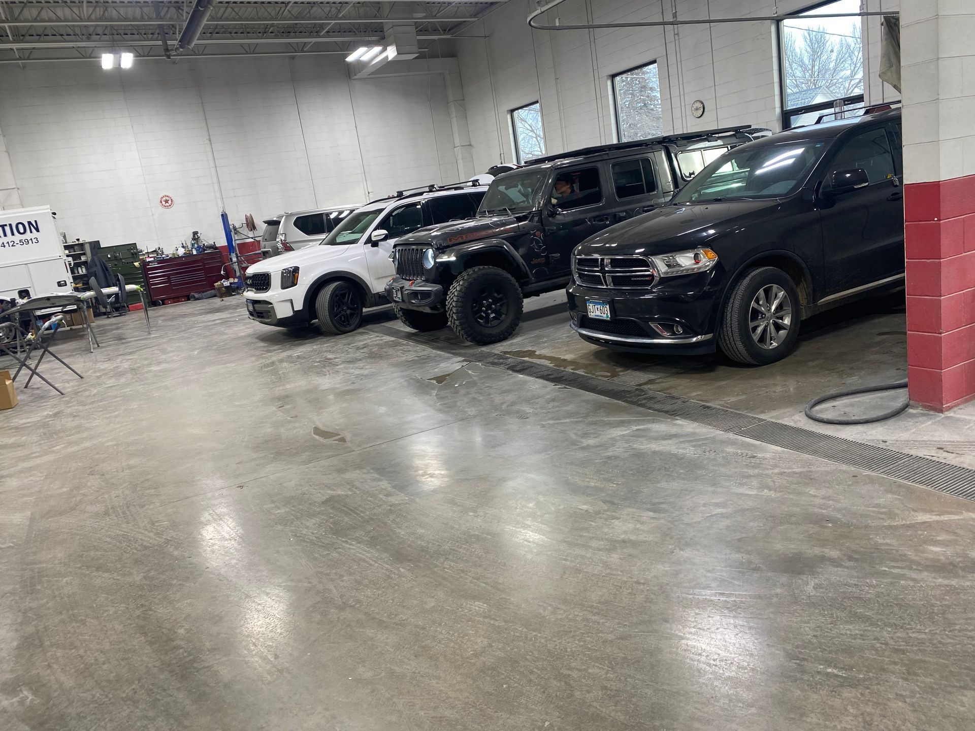 A row of cars are parked in a garage.