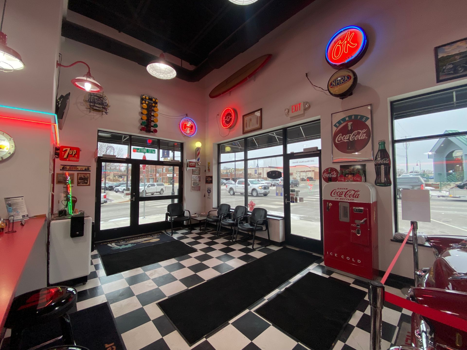 A waiting room with a checkered floor and a coca cola machine.